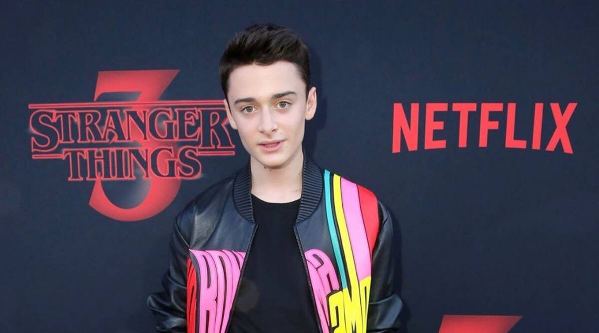  壁紙 — 年輕演員穿著彩色外套在Stranger Things Netflix活動中於黑暗背景下擺姿勢。