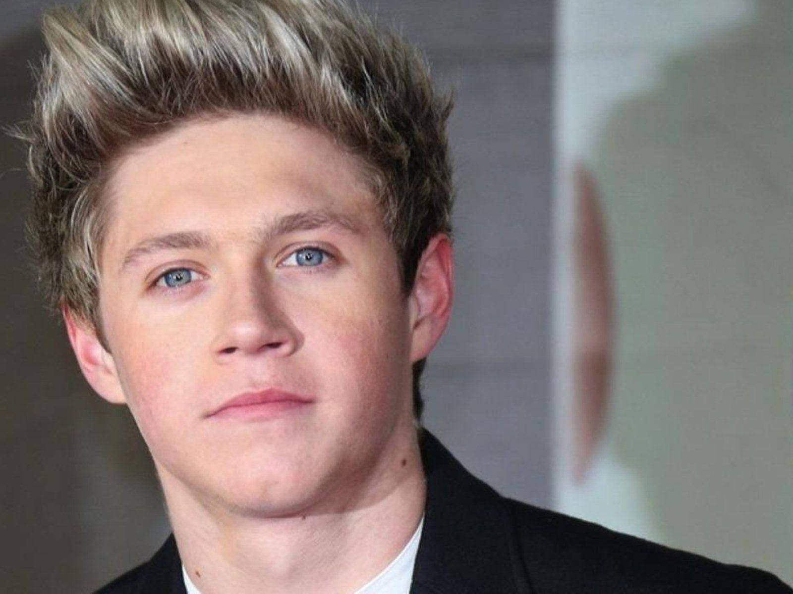 niall horan 桌布 壁紙 — 年輕男子特寫肖像照，一頭刺狀金髮，一雙引人注目的藍眼睛，身穿黑色西裝外套。