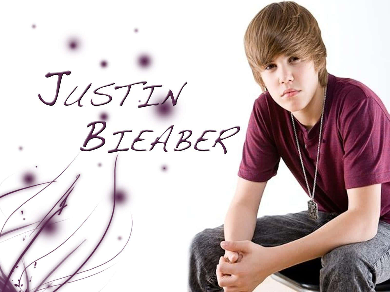 小賈斯汀 桌布 壁紙 — 年輕的Justin Bieber穿著栗色襯衫，在白色背景上帶有紫色文字和抽象漩渦，沉思地坐著。