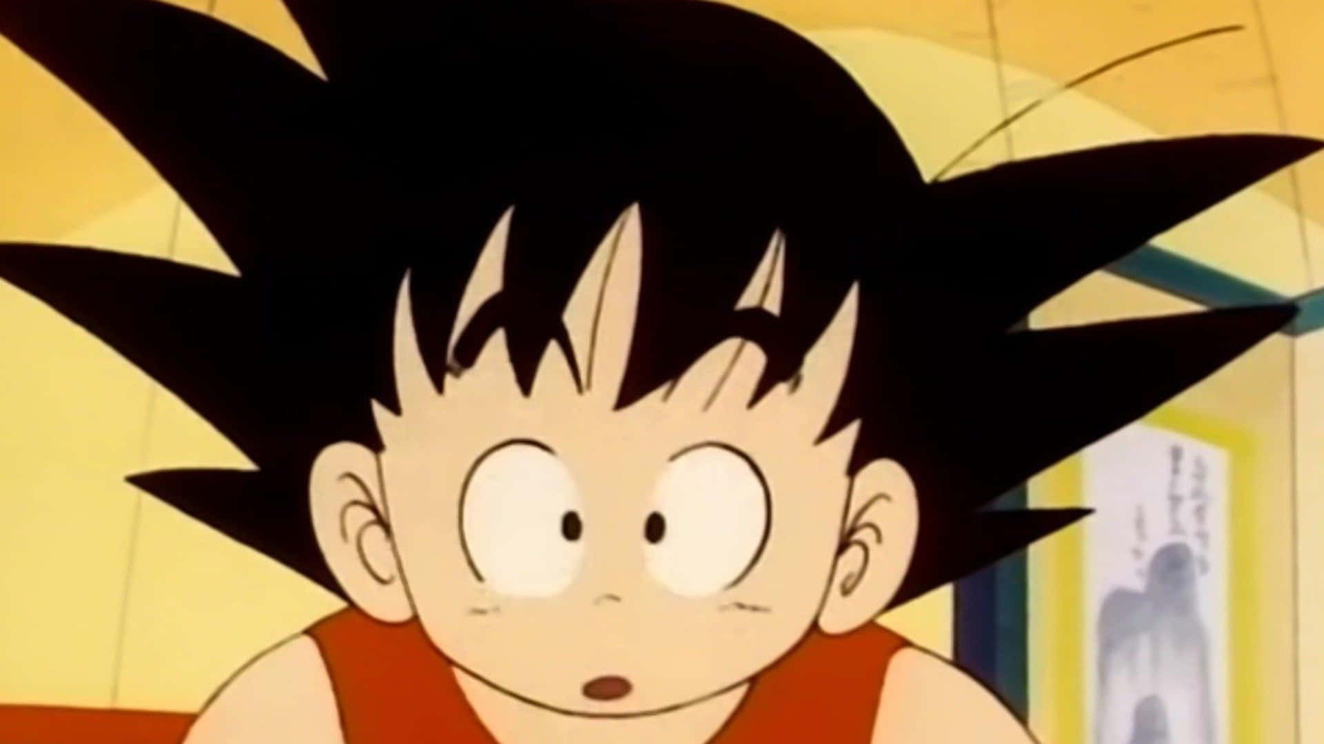 Funny Goku 桌布 壁紙 — 年輕的悟空有著刺蝟般的黑髮和大眼睛，穿著橙色背心，驚訝地凝視著。