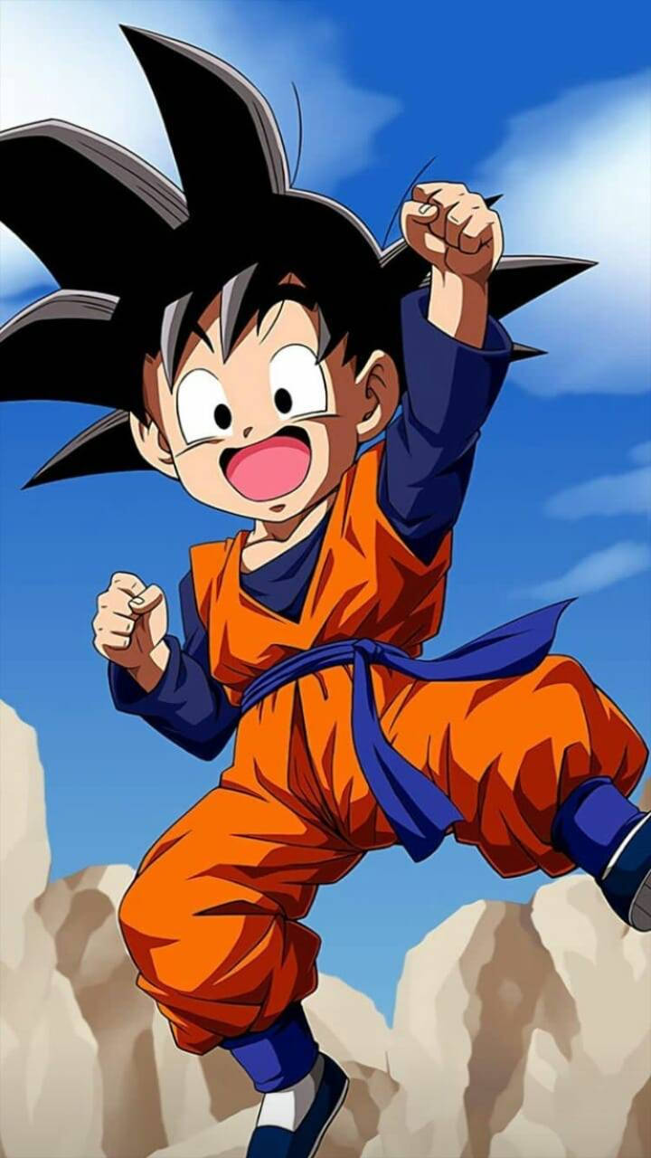 Goten 桌布 壁紙 — 年輕的悟空穿著橙色道服，在藍天白雲下充滿活力地跳過岩石地形。