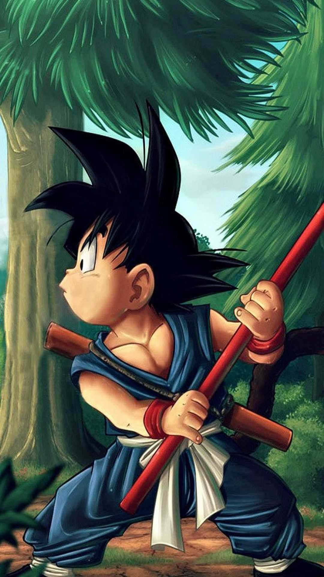 kid goku 桌布 壁紙 — 年輕的悟空站在森林中，手持他標誌性的紅色如意棒，神情堅定。