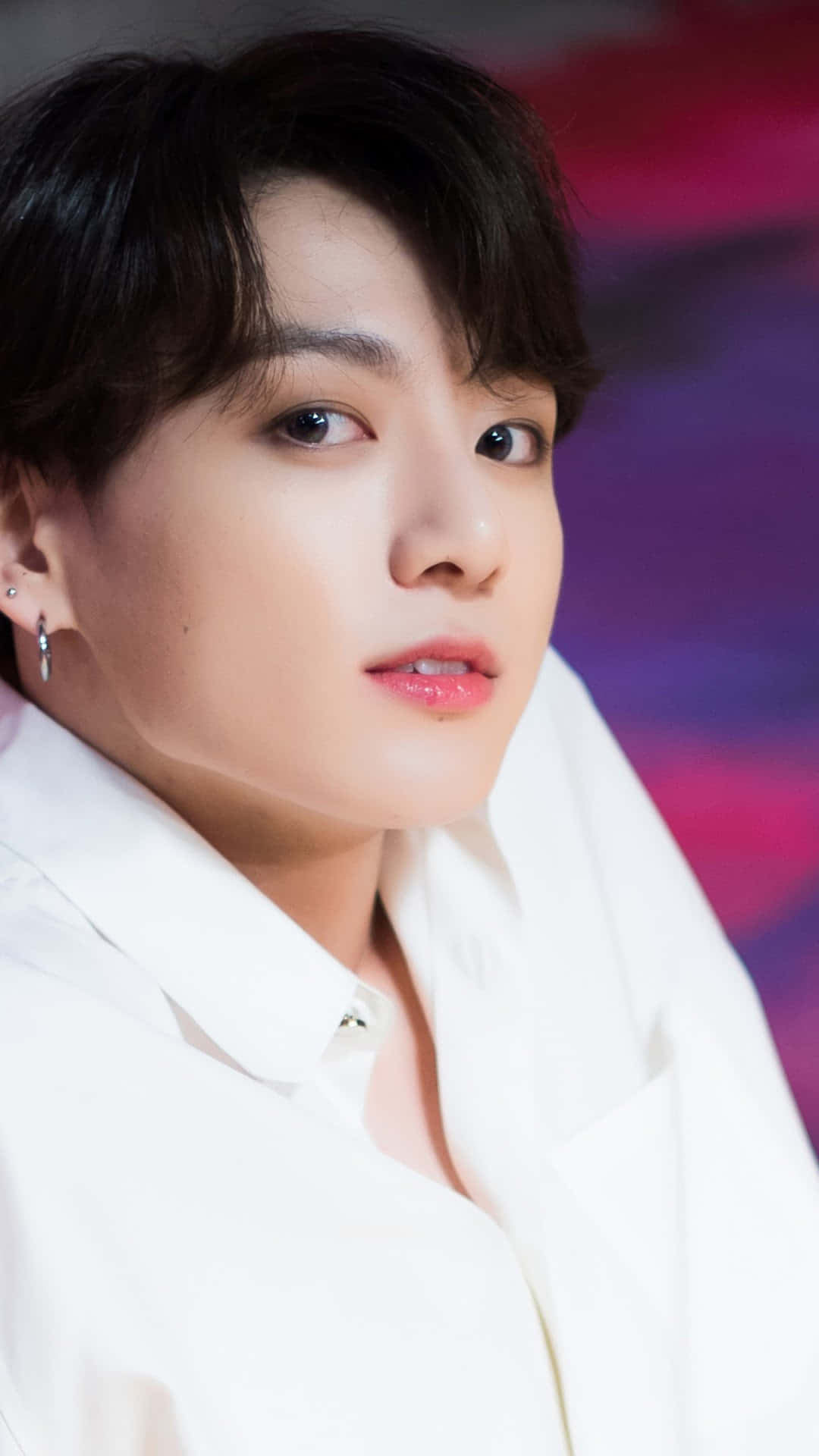 Jungkook 桌布 壁紙 — 年輕黑髮白衫男子特寫肖像，背景為鮮豔的紫色和粉紅色模糊效果。