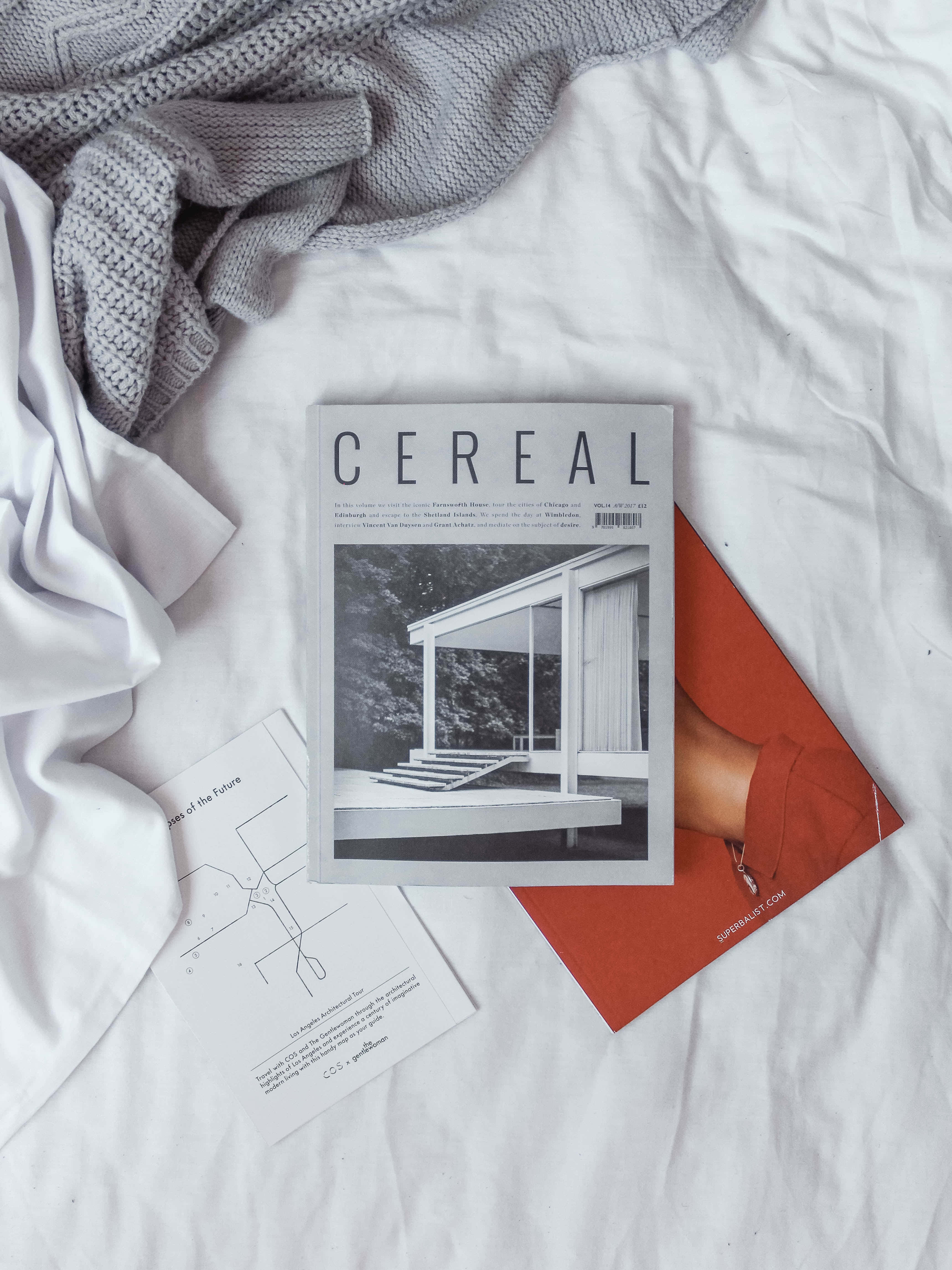 雜誌 桌布 壁紙 — 床上CEREAL雜誌、白色亞麻布、灰色針織品和橙色信封的極簡平鋪佈置。