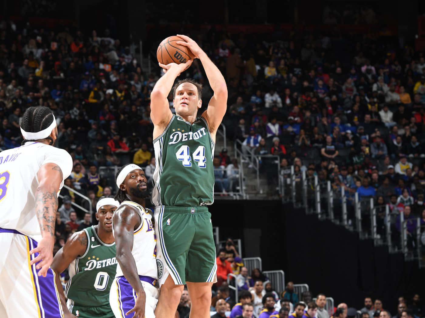 NBA 桌布 壁紙 — 底特律活塞隊球員身穿綠色44號球衣，在擠滿觀眾的室內比賽中專注地投籃。