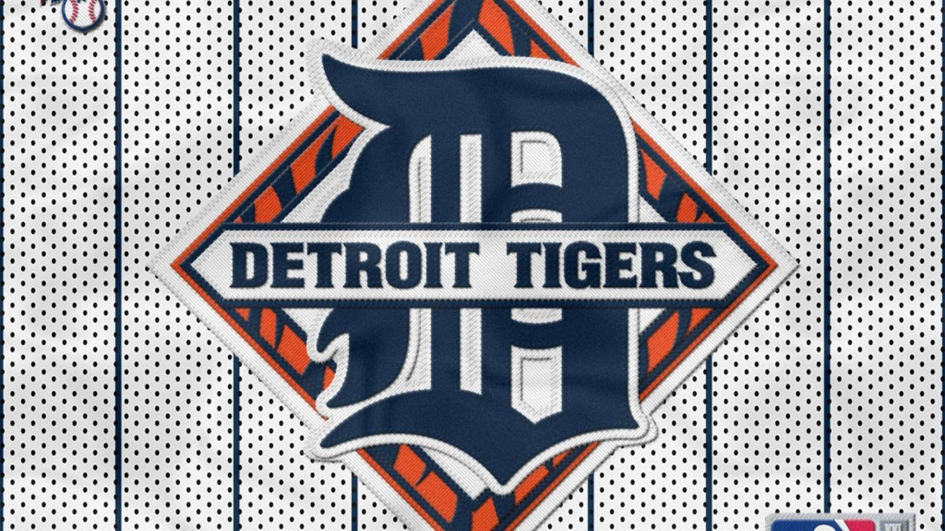 tigers 桌布 壁紙 — 底特律老虎隊棒球球衣標誌特寫，帶有鮮明的藍色、橙色和白色條紋布料質感。