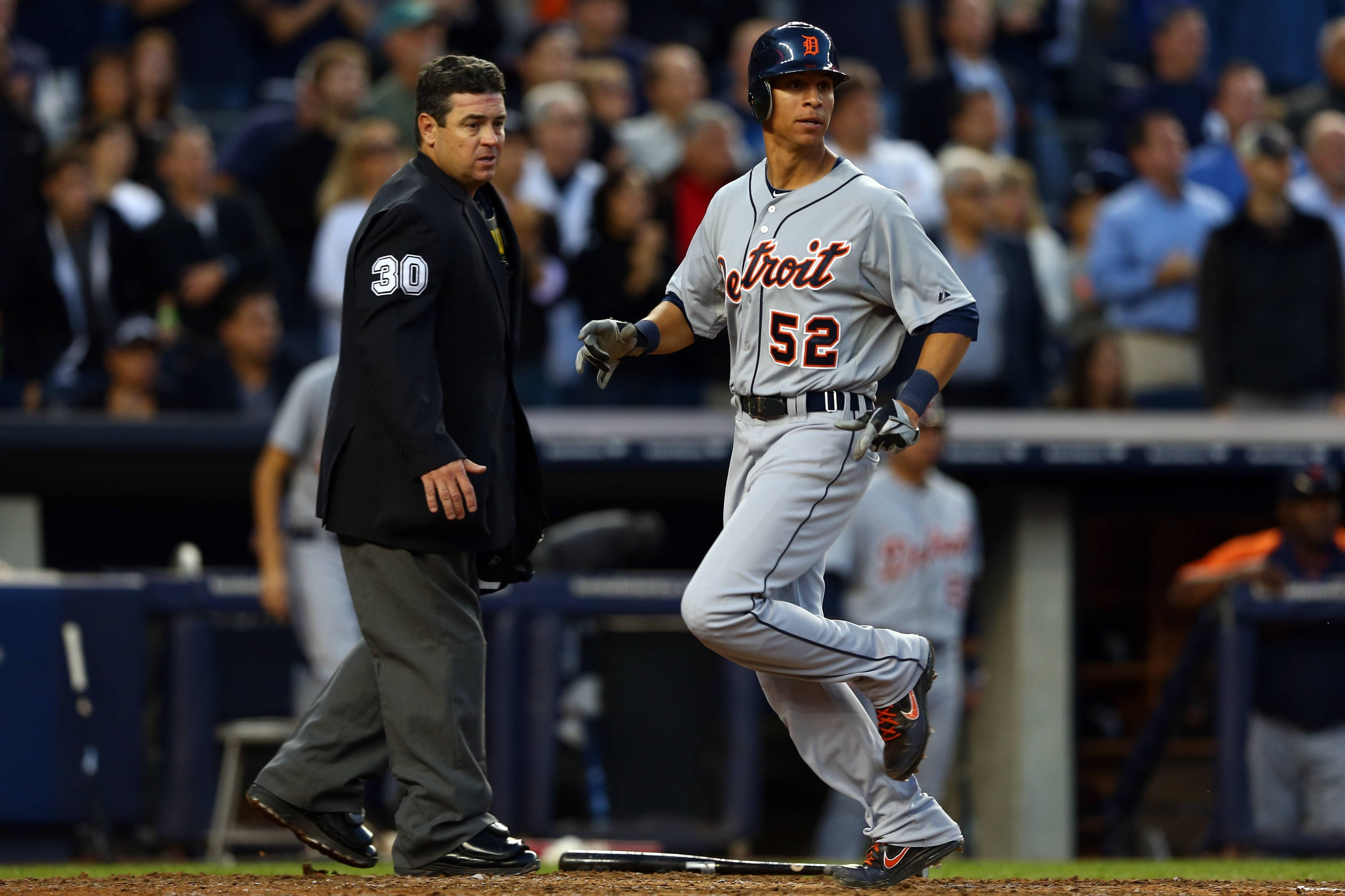 tigers 桌布 壁紙 — 底特律老虎隊的灰色球衣棒球選手在夜間比賽中於球場燈光下衝刺經過裁判。