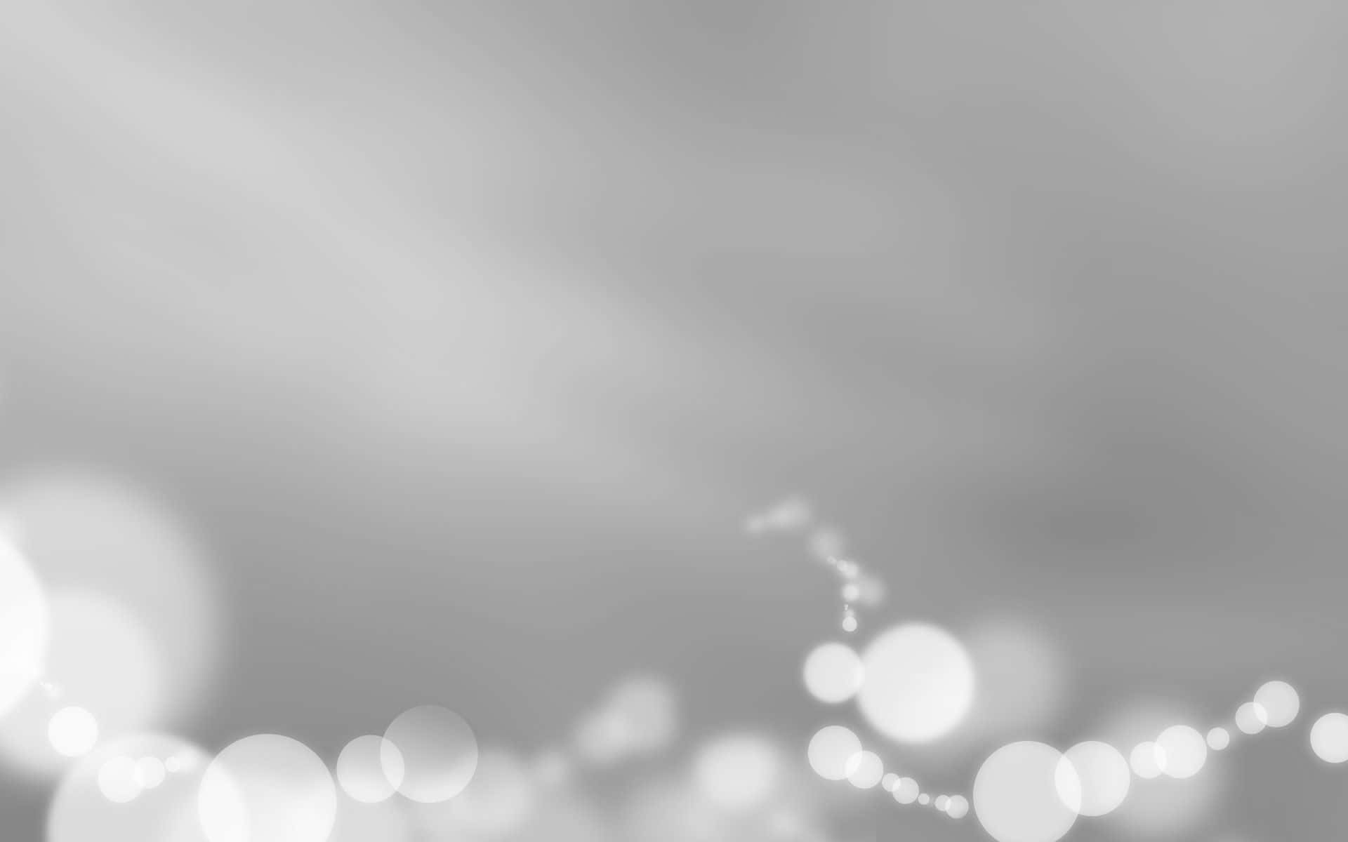 Light Gray 桌布 壁紙 — 底部帶有散落發光散景燈光的柔和灰色漸變背景。