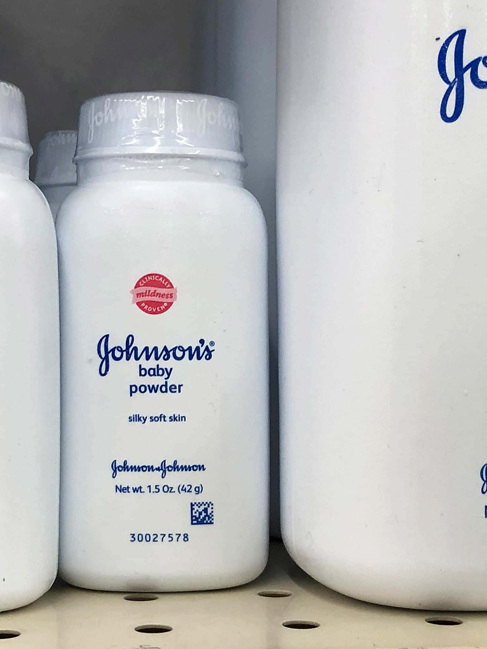 Baby Powder 桌布 壁紙 — 店鋪貨架上強生嬰兒爽身粉瓶的特寫，品牌標示和淨重清晰可見。