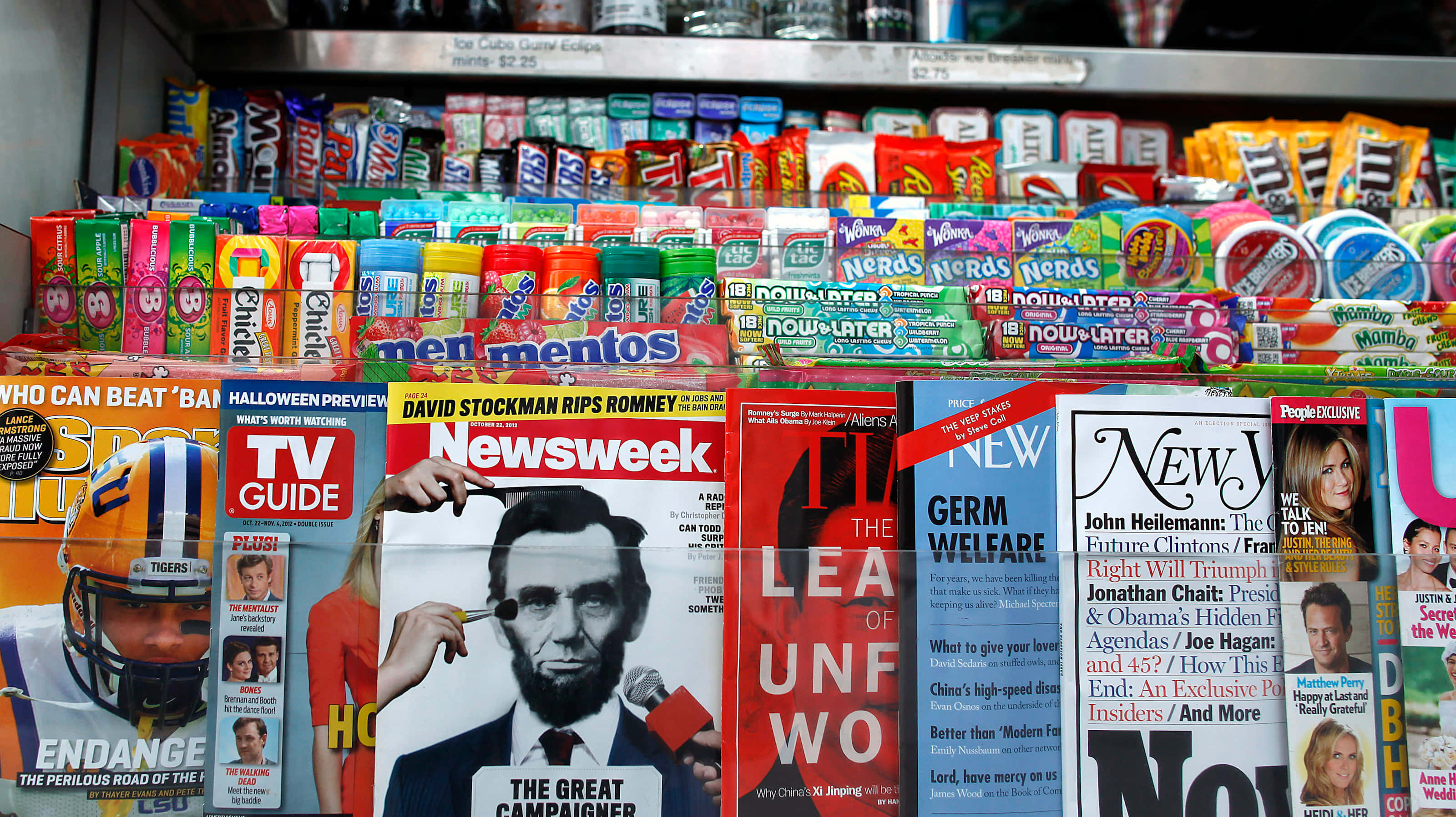 Magazine 桌布 壁紙 — 店鋪貨架上色彩繽紛的糖果棒和雜誌，搭配大膽標題和明亮包裝，充滿活力。