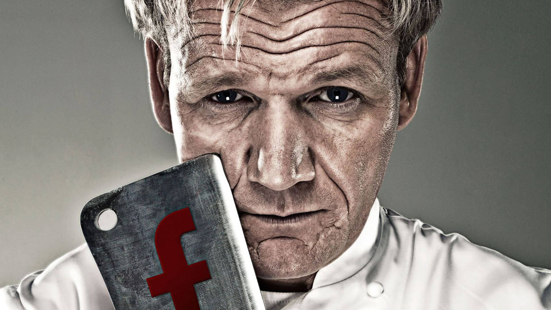 高登·拉姆齊 桌布 壁紙 — 廚師戈登·拉姆齊（Gordon Ramsay）手持帶有紅色Facebook標誌的切肉刀，眼神專注。