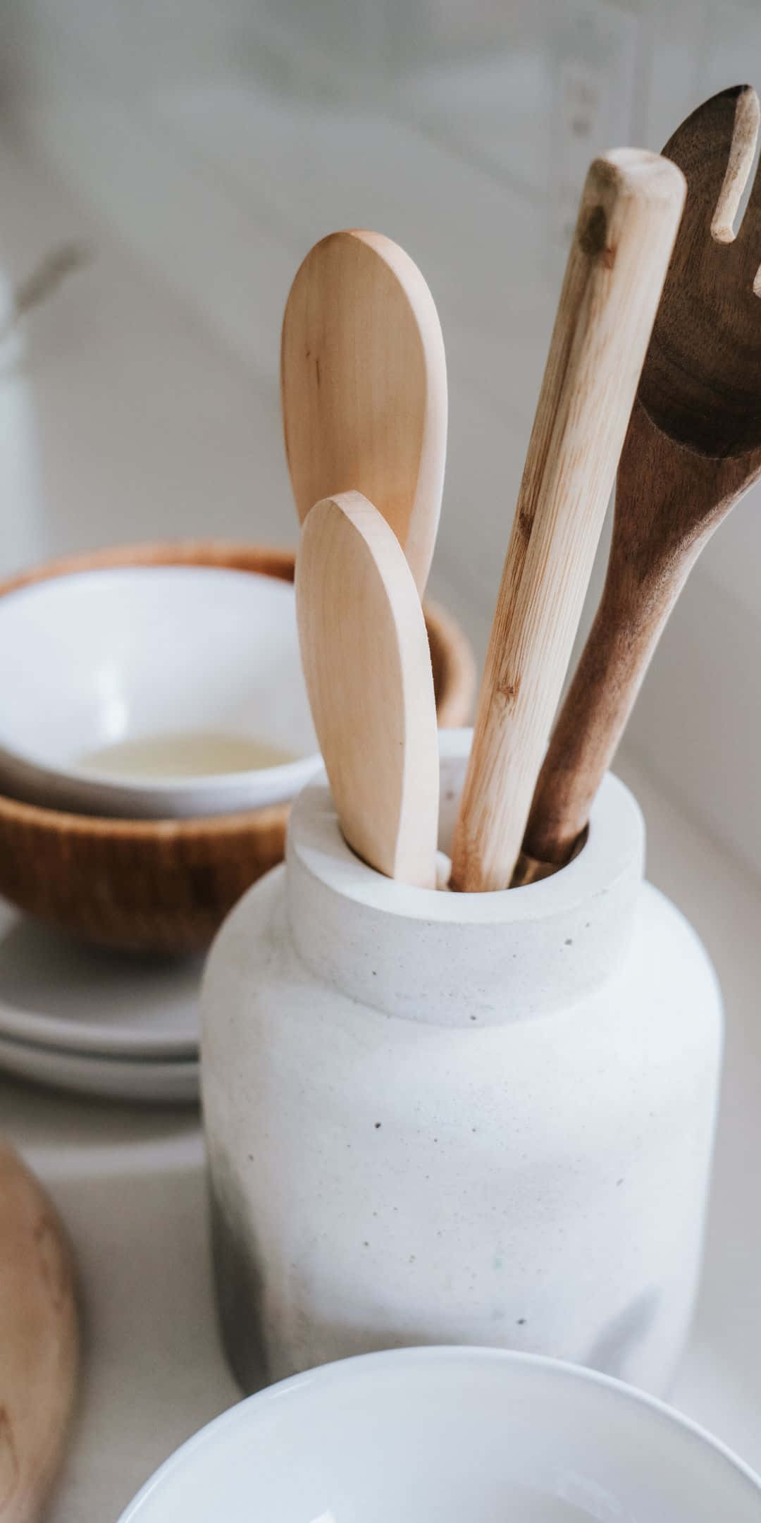 Pixel 3 Kitchen 桌布 壁紙 — 廚房檯面上堆疊的碗旁邊，一個有斑點的白色陶瓷架中木製湯匙和叉子的特寫。