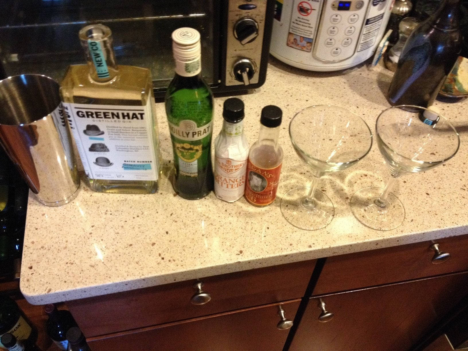 alcohol 桌布 壁紙 — 廚房檯面展示了雞尾酒材料，包括琴酒、苦精和兩個準備調製的空馬丁尼杯。