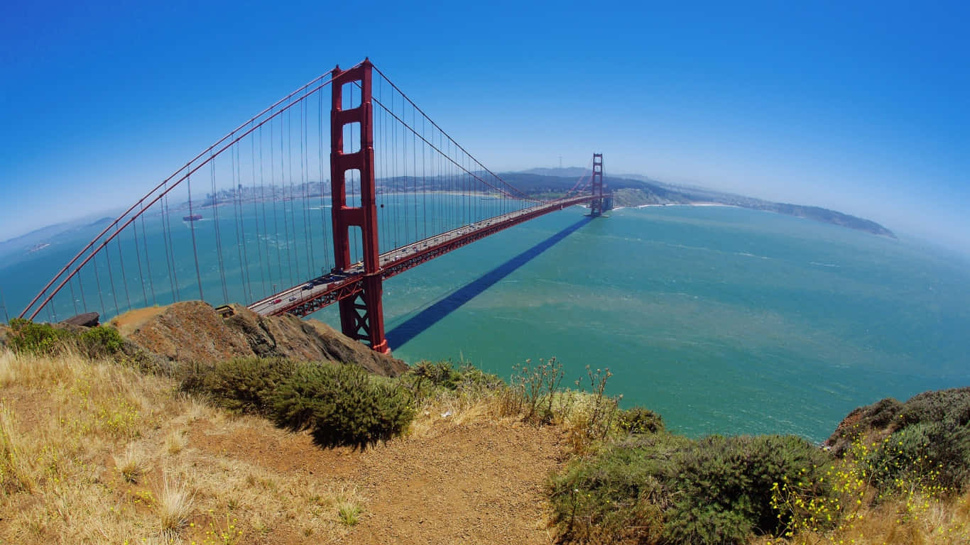 1366x768 San Francisco 桌布 壁紙 — 廣角視角下的標誌性紅色金門大橋，橫跨在清澈藍天下的碧綠海水上。