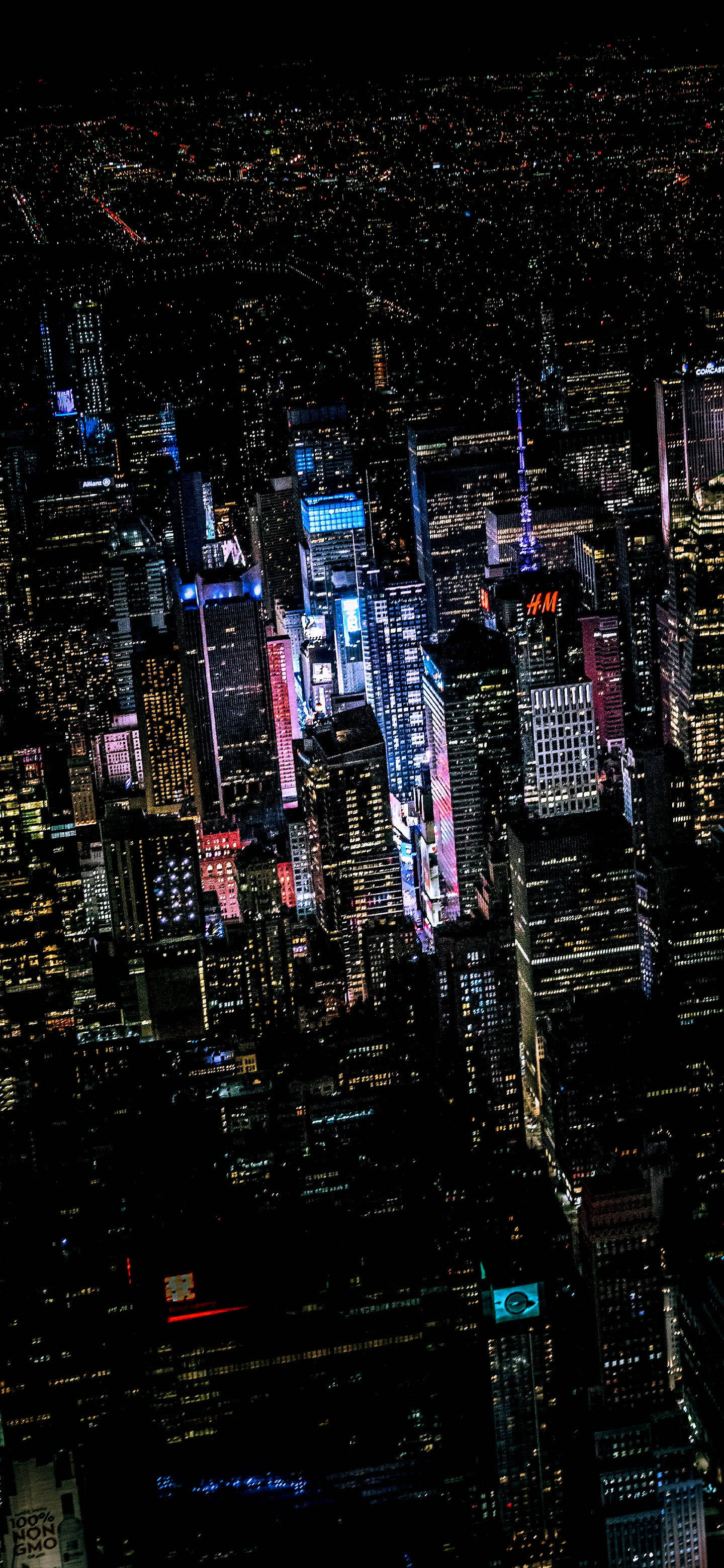 New 桌布 壁紙 — 廣闊城市夜景的鳥瞰圖，高聳的摩天大樓在黑暗的天空中閃爍著鮮豔的霓虹燈光。