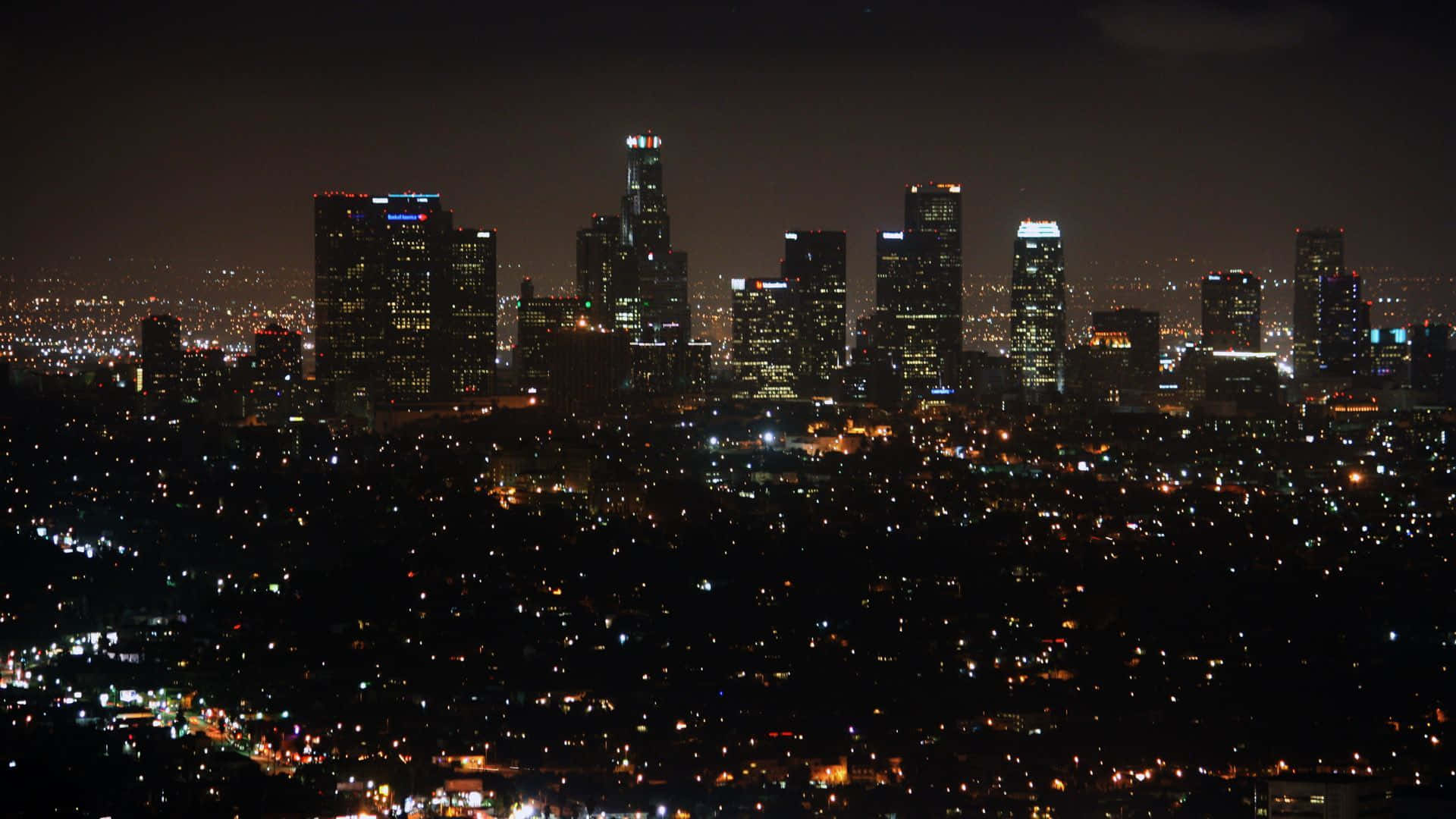 城市 桌布 壁紙 — 廣闊城市景觀的 panoramatic 夜景，高聳的摩天大樓在黑暗的天空中閃耀。