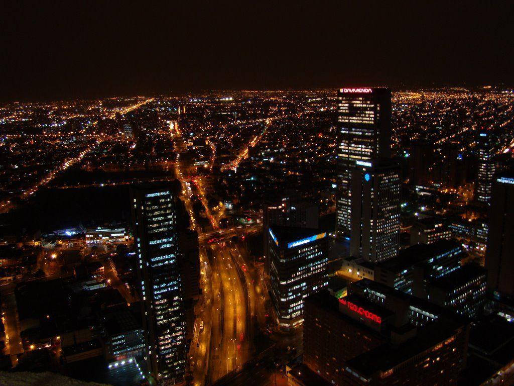 Bogota 桌布 壁紙 — 廣闊城市景觀的夜間鳥瞰圖，下方有發光的摩天大樓和照明街道。