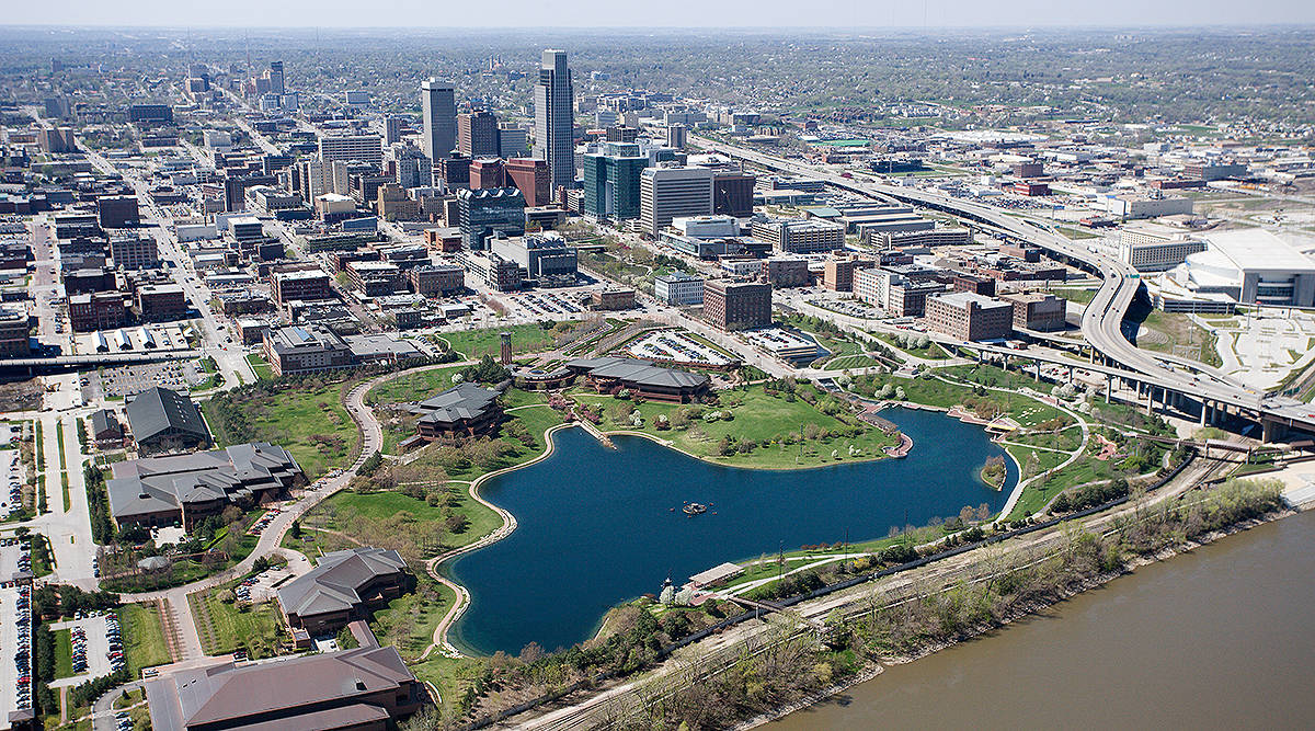 Nebraska 桌布 壁紙 — 廣闊城市景觀的鳥瞰圖，一個大型藍色湖泊被綠色公園和現代摩天大樓環繞。