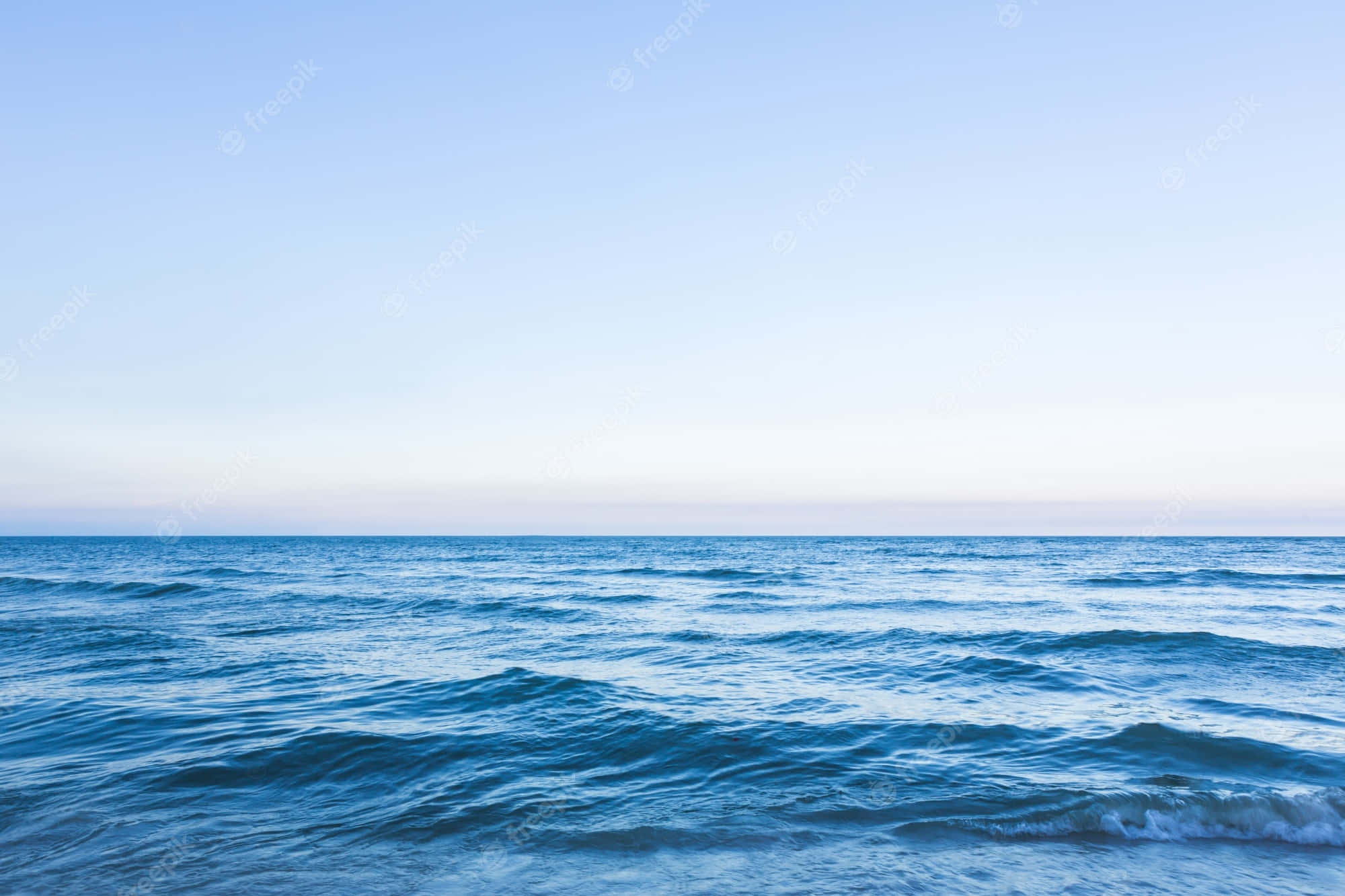 海洋 桌布 壁紙 — 廣闊平靜的海洋在柔和粉彩天空下延伸至地平線，寧靜的黎明。