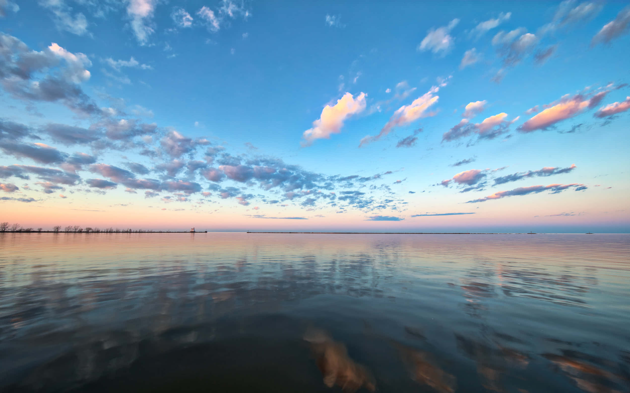 Lake Erie 桌布 壁紙 — 廣闊平靜的湖面上，粉紅色和藍色的雲彩倒映在水中，呈現出寧靜的日落景象。