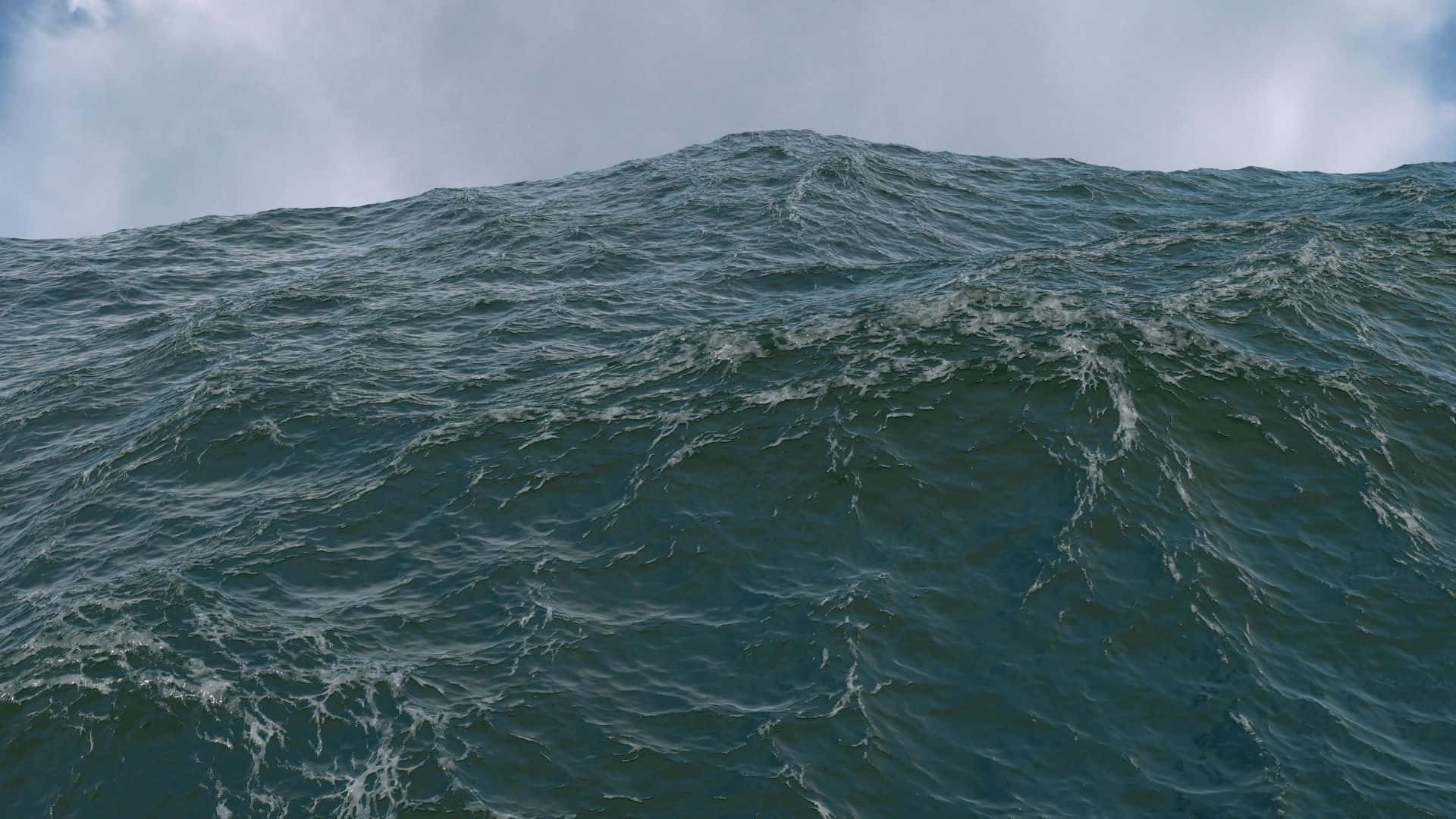 3d Ocean 桌布 壁紙 — 廣闊洶湧的海洋，深藍綠色的波浪在陰天天空下翻騰。