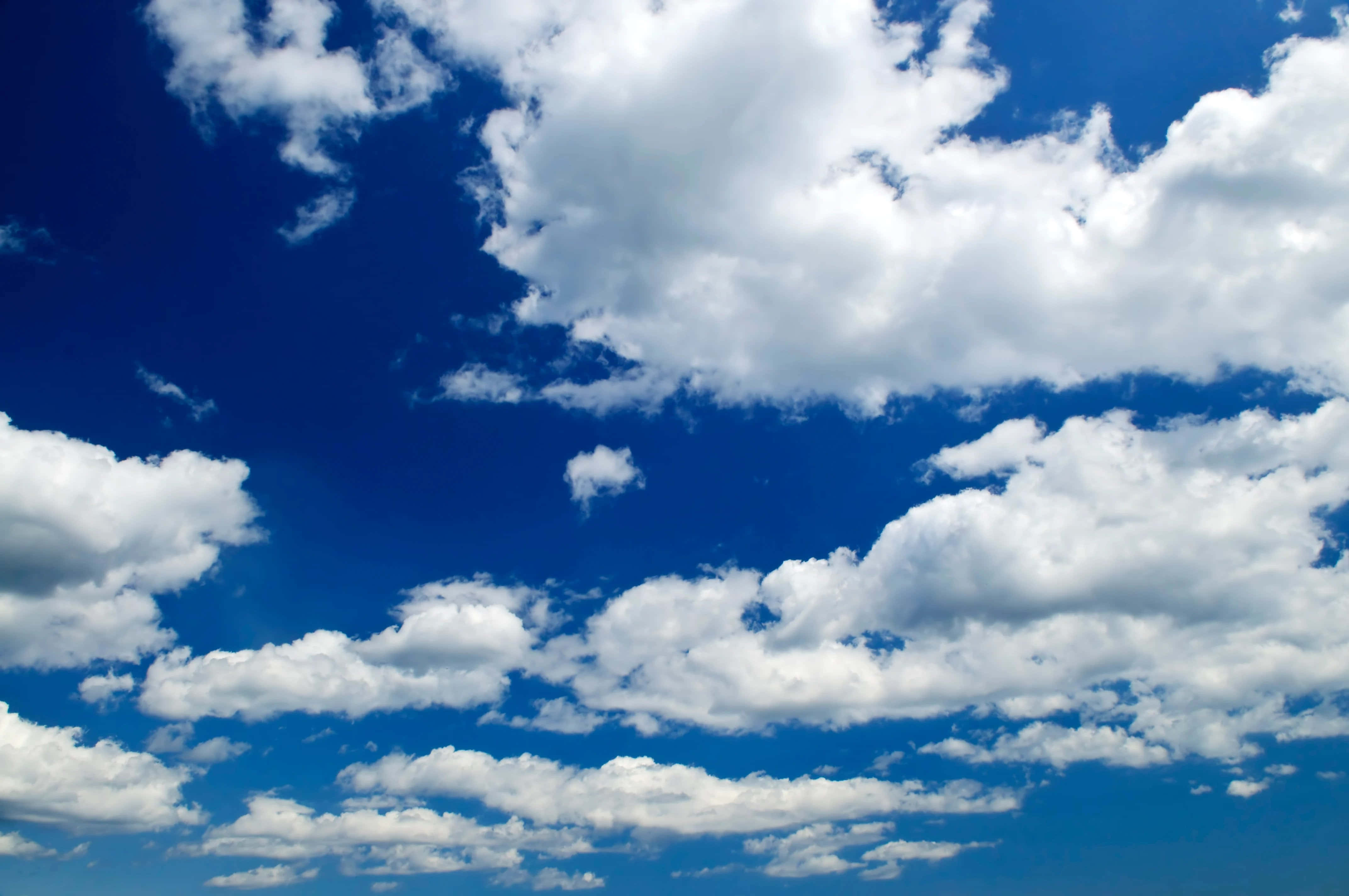 Blue Sky 桌布 壁紙 — 廣闊深藍天空，充滿蓬鬆白雲，在晴朗陽光燦爛的日子飄移。
