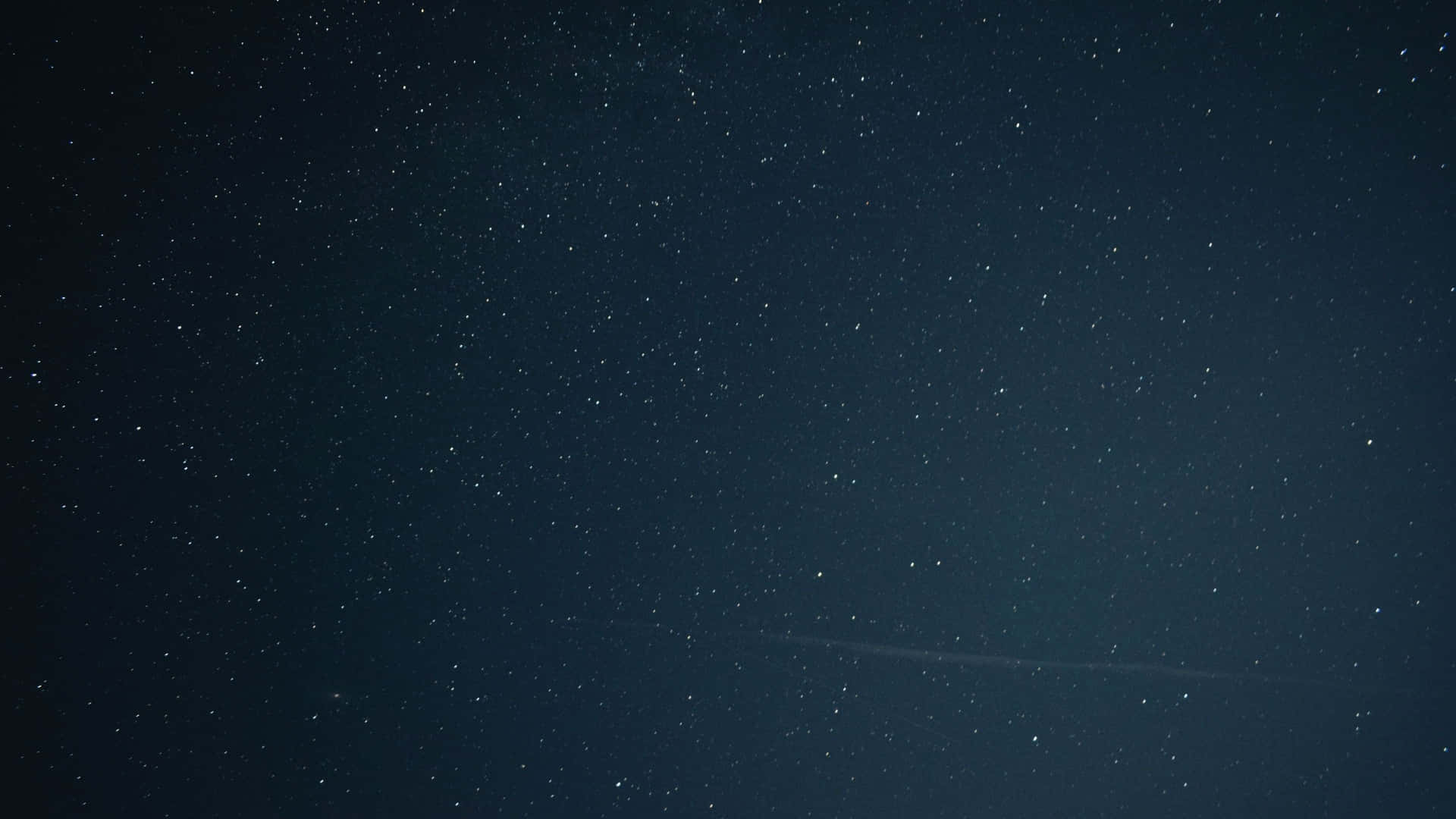 Starry Sky 桌布 壁紙 — 廣闊深藍色夜空，充滿無數閃爍星星和一條微弱的水平飛機軌跡。