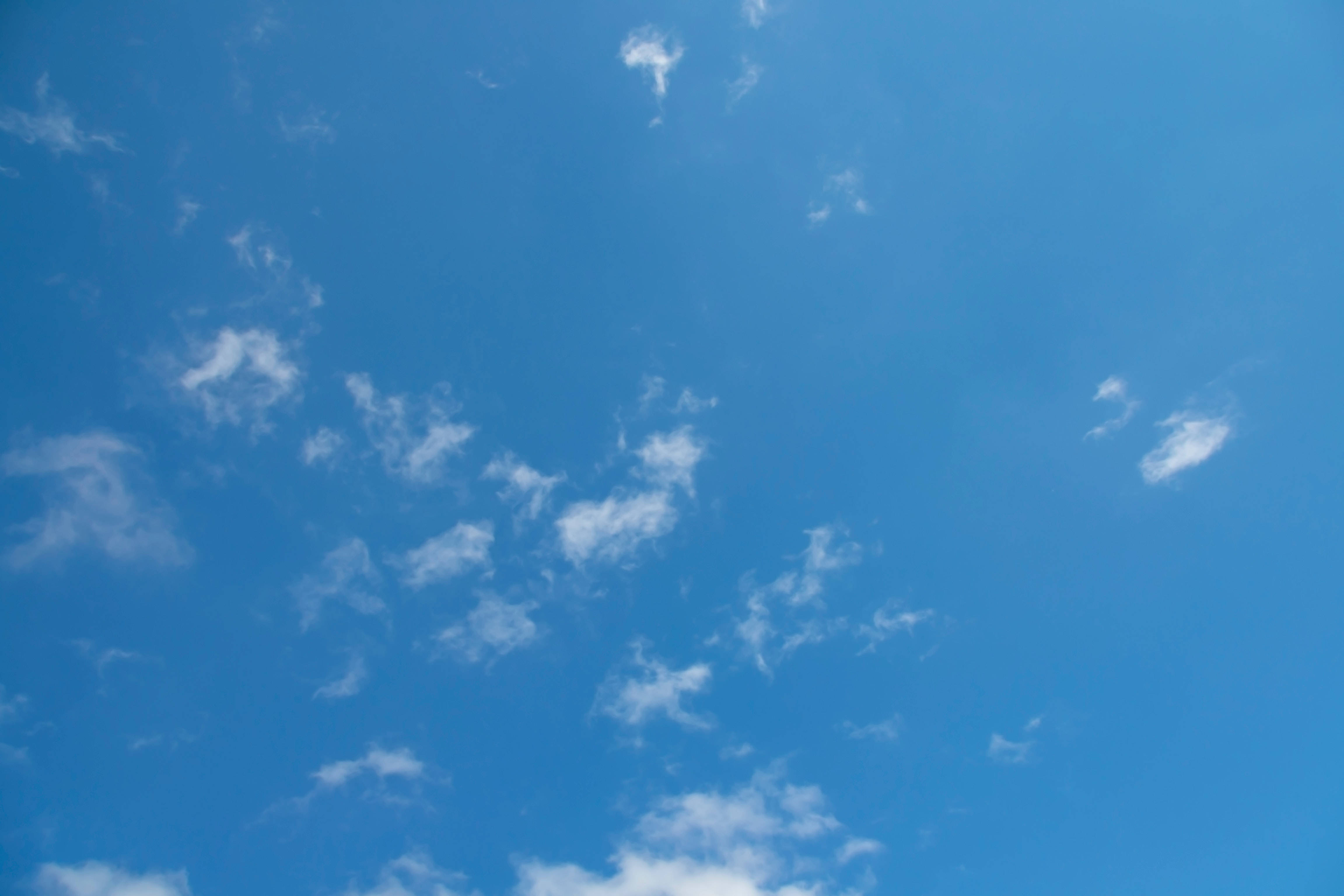 Blue Sky 桌布 壁紙 — 廣闊清澈的藍天點綴著縷縷白雲，懶洋洋地飄浮在頭頂。