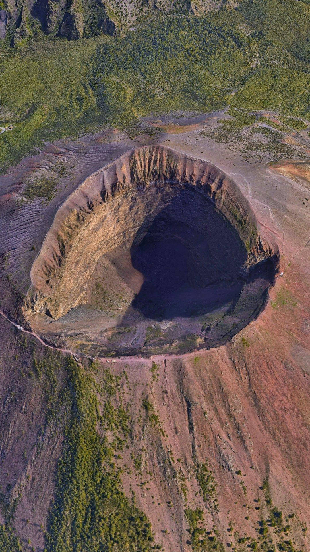 Pixel 4 桌布 壁紙 — 廣闊火山口的鳥瞰圖，陡峭的梯田狀岩壁，邊緣環繞著茂密的綠色植被。