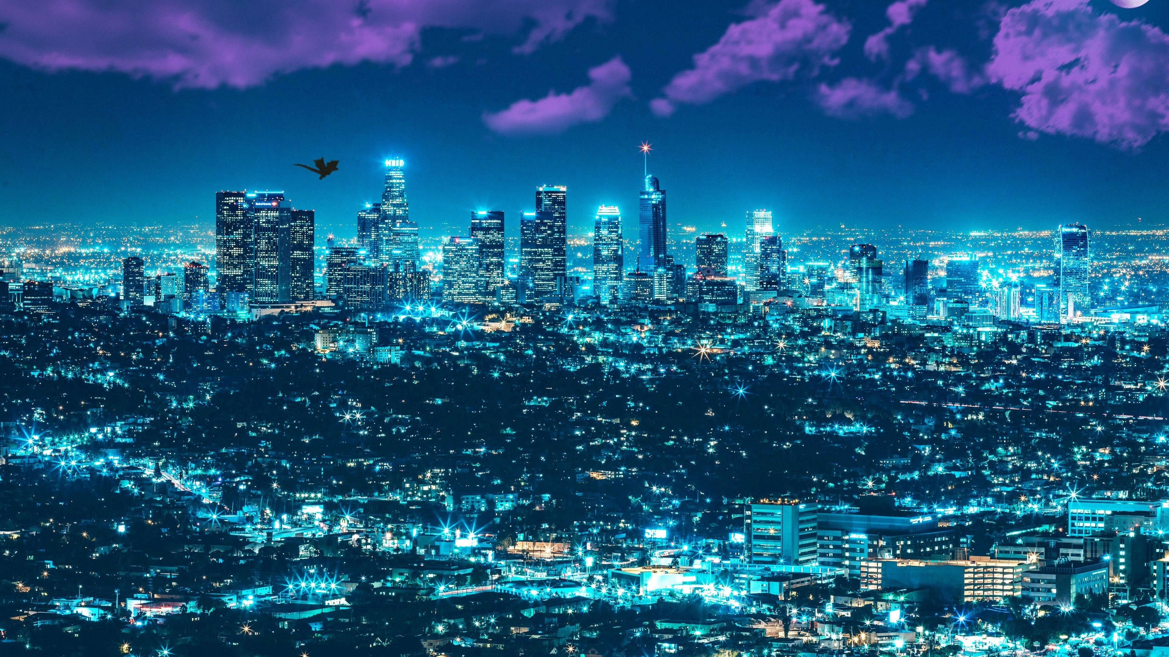 洛杉磯 4K 桌布 壁紙 — 廣闊的城市夜景，沐浴在電光藍色霓虹燈下，上方是戲劇性的紫色多雲天空。