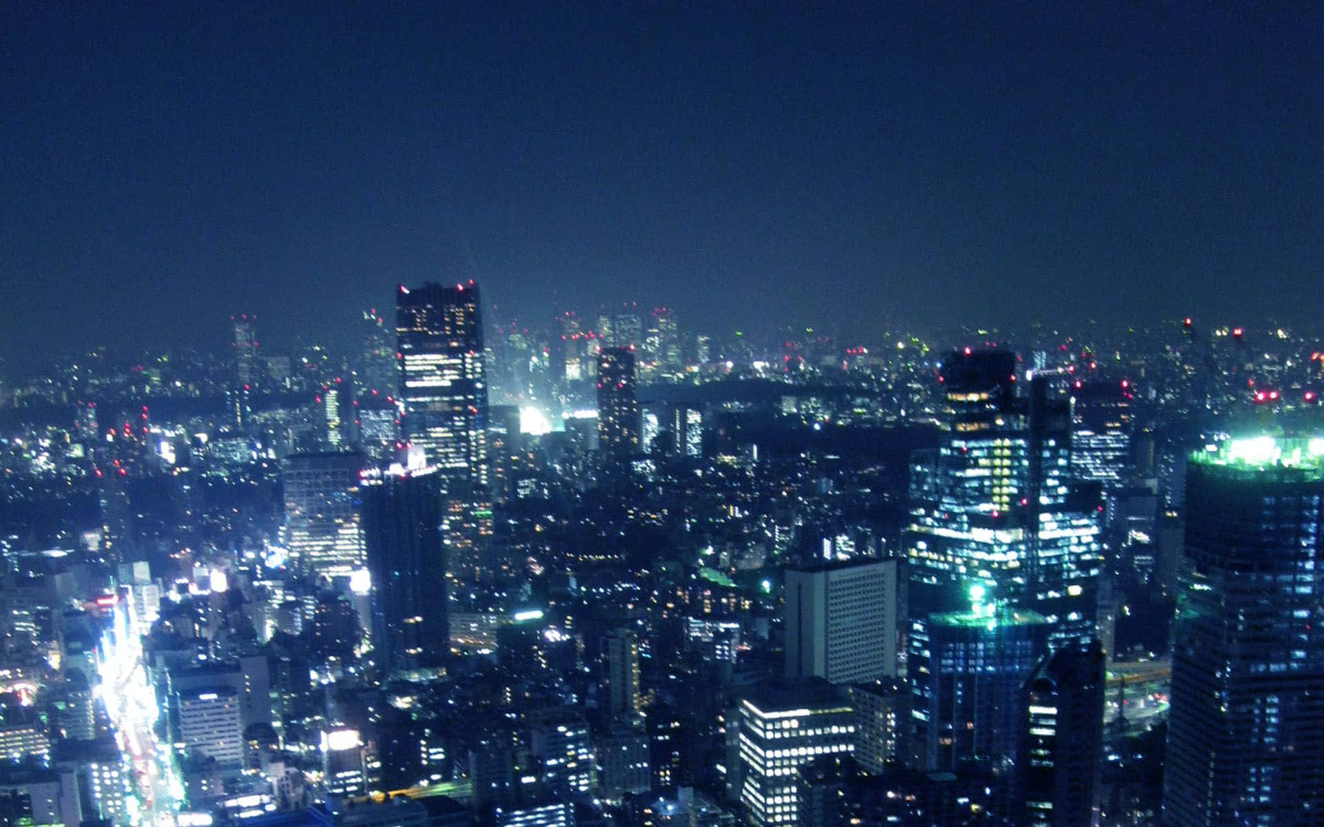 城市 桌布 壁紙 — 廣闊的城市夜景，無數燈火通明的摩天大樓和發光的街道在黑暗的天空下。