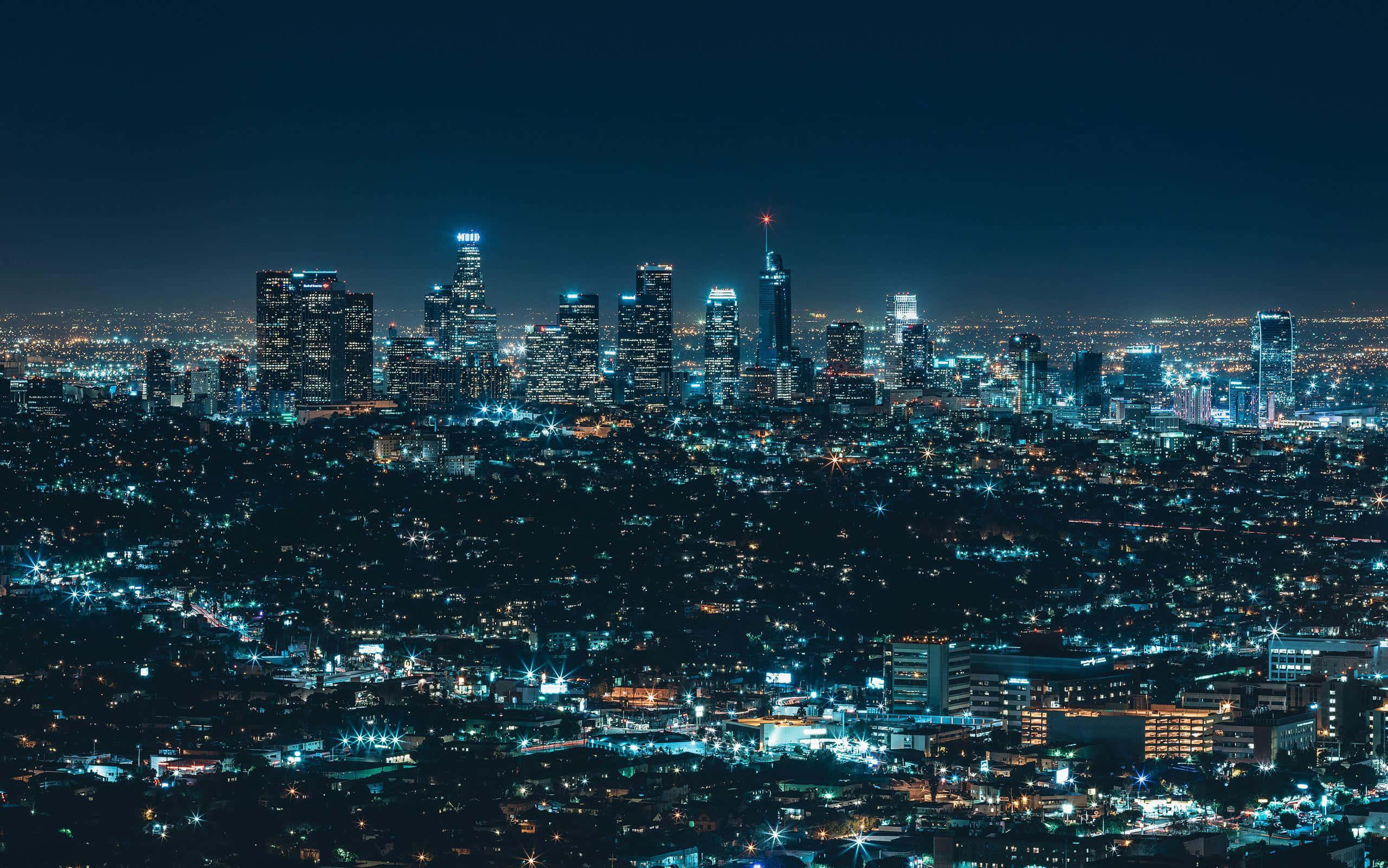 City Night 桌布 壁紙 — 廣闊的城市夜景，高聳的摩天大樓和發光的街道在黑暗的天空下。