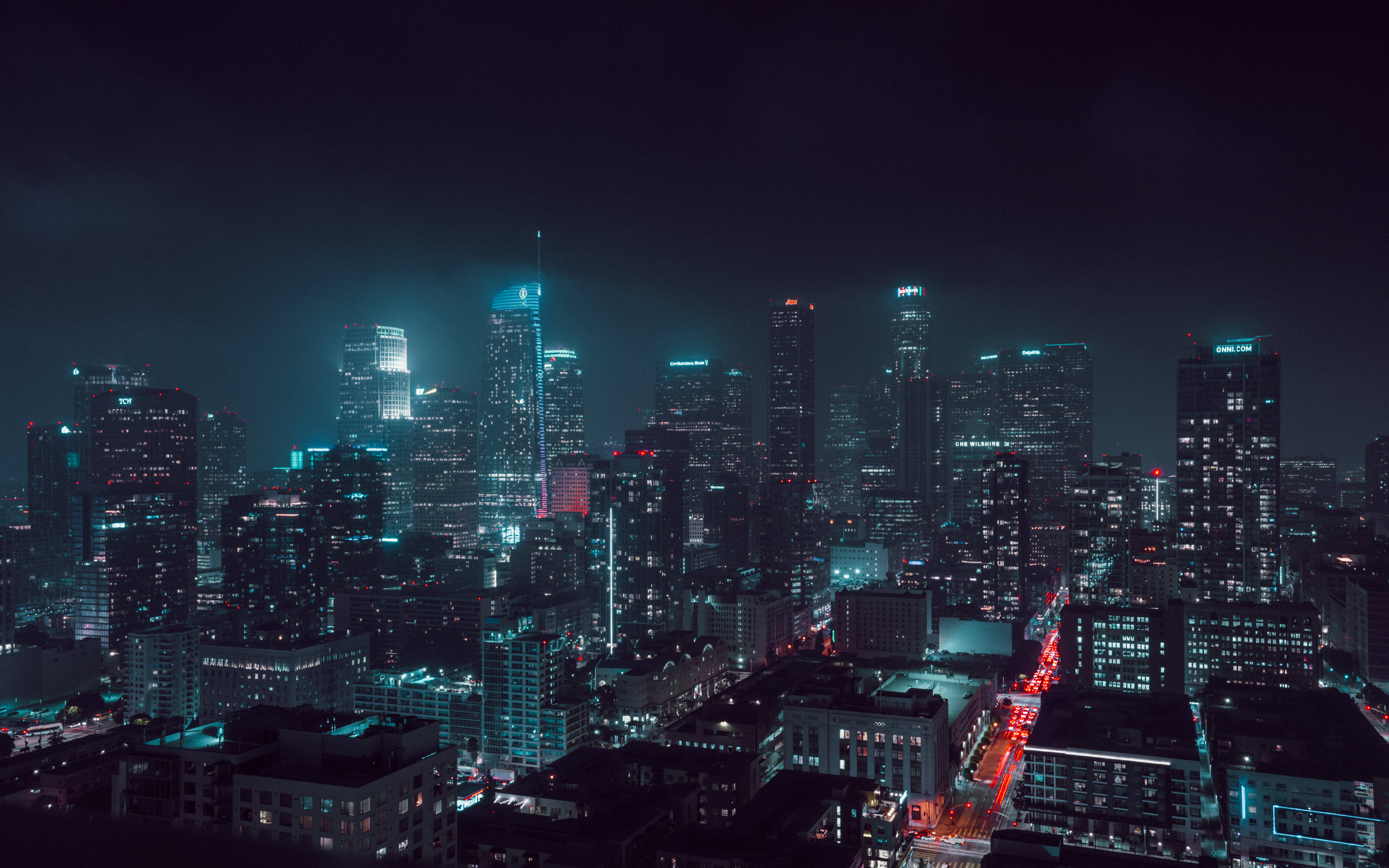 銀翼殺手2049 桌布 壁紙 — 廣闊的城市天際線夜景，摩天大樓閃爍，紅色車燈在黑暗的天空下劃出線條。