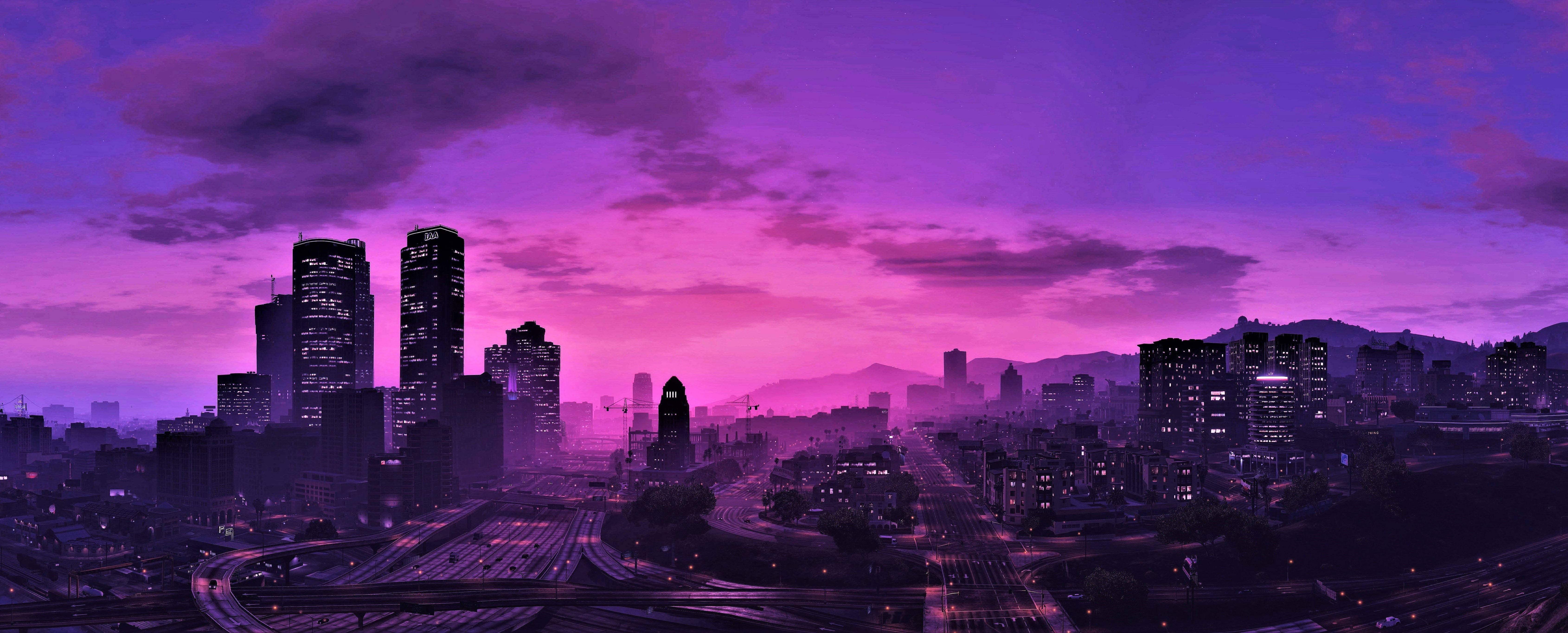 Purple Gaming 桌布 壁紙 — 廣闊的城市景觀在黃昏時分沐浴在充滿活力的紫色和粉紅色調中，點亮的摩天大樓和蜿蜒的道路。