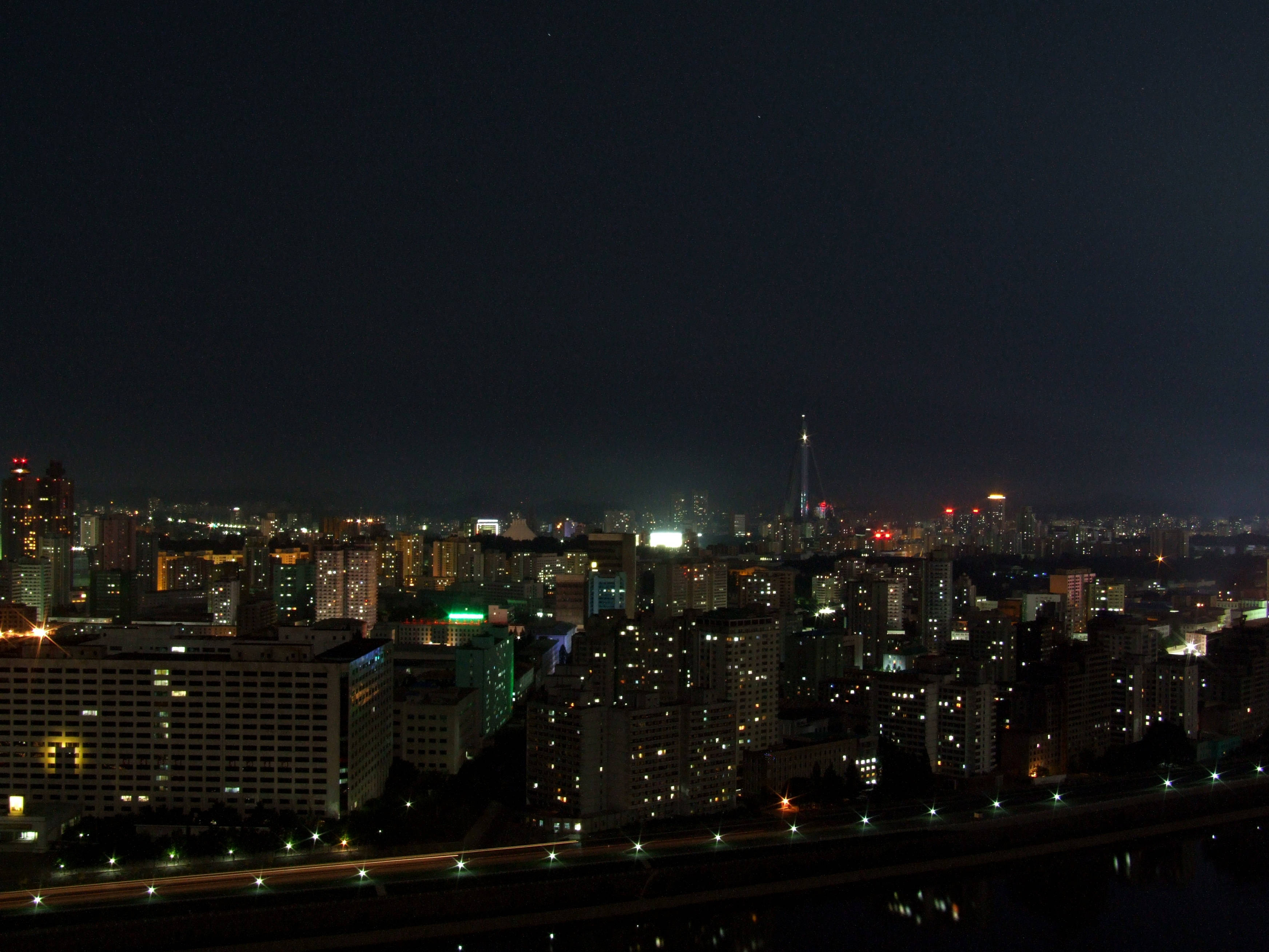 韓國 桌布 壁紙 — 廣闊的夜景城市景觀，無數發光的窗戶和一條在黑暗天空下反射路燈的河流。