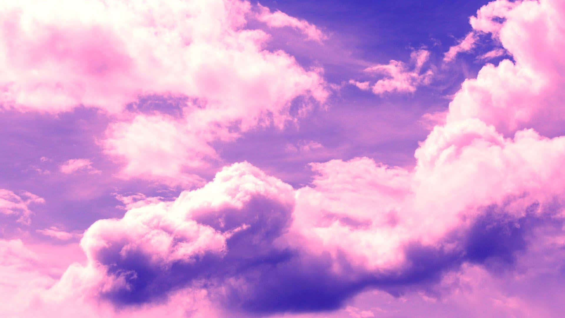 Aesthetic Cloud 桌布 壁紙 — 廣闊的天空充滿了蓬鬆的雲朵，在夢幻般的暮色下散發出柔和的粉紅色和紫色色調。
