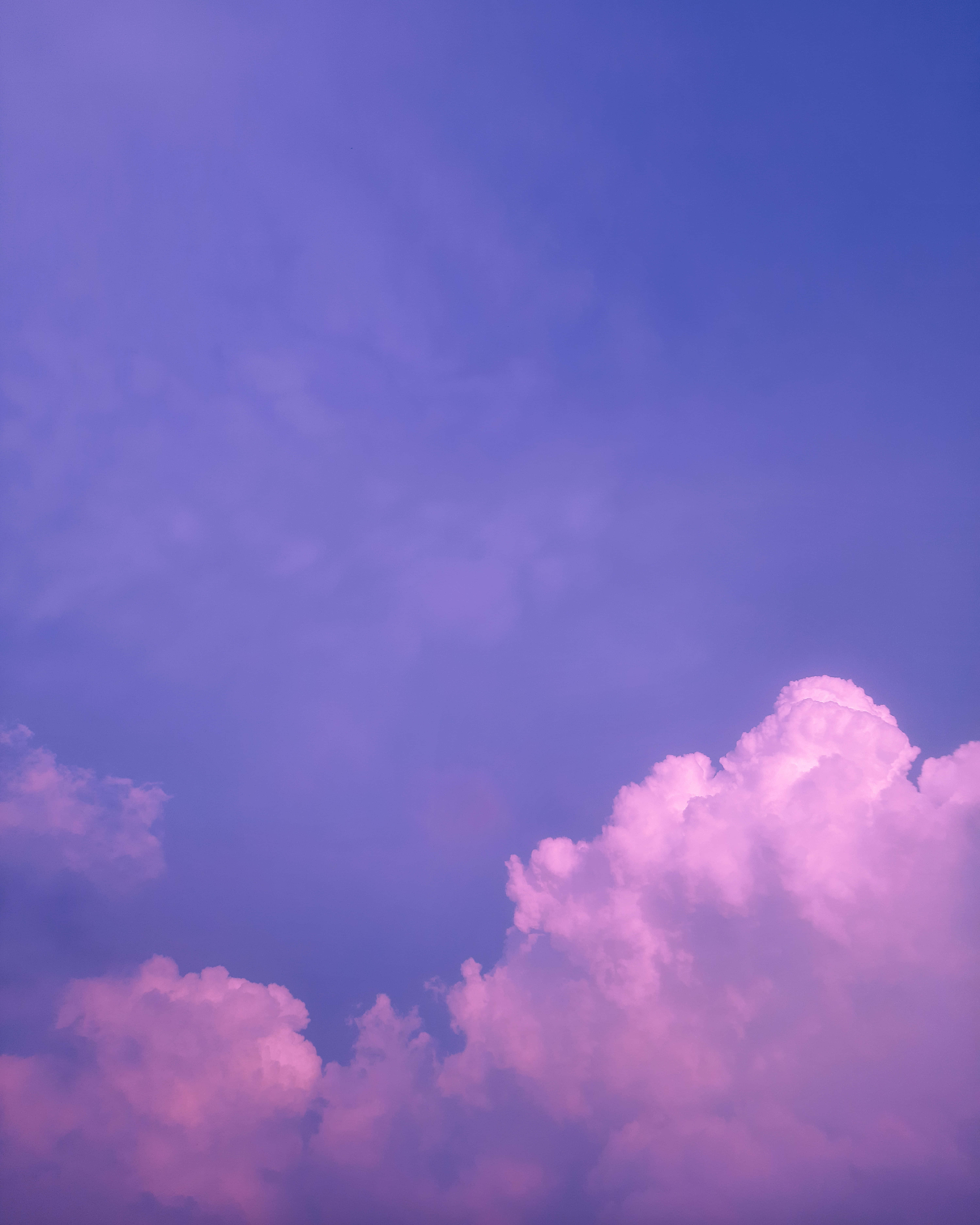 Aesthetic Sky 桌布 壁紙 — 廣闊的天空塗上夢幻的紫色和粉紅色調，柔軟的雲彩在日落時發光。