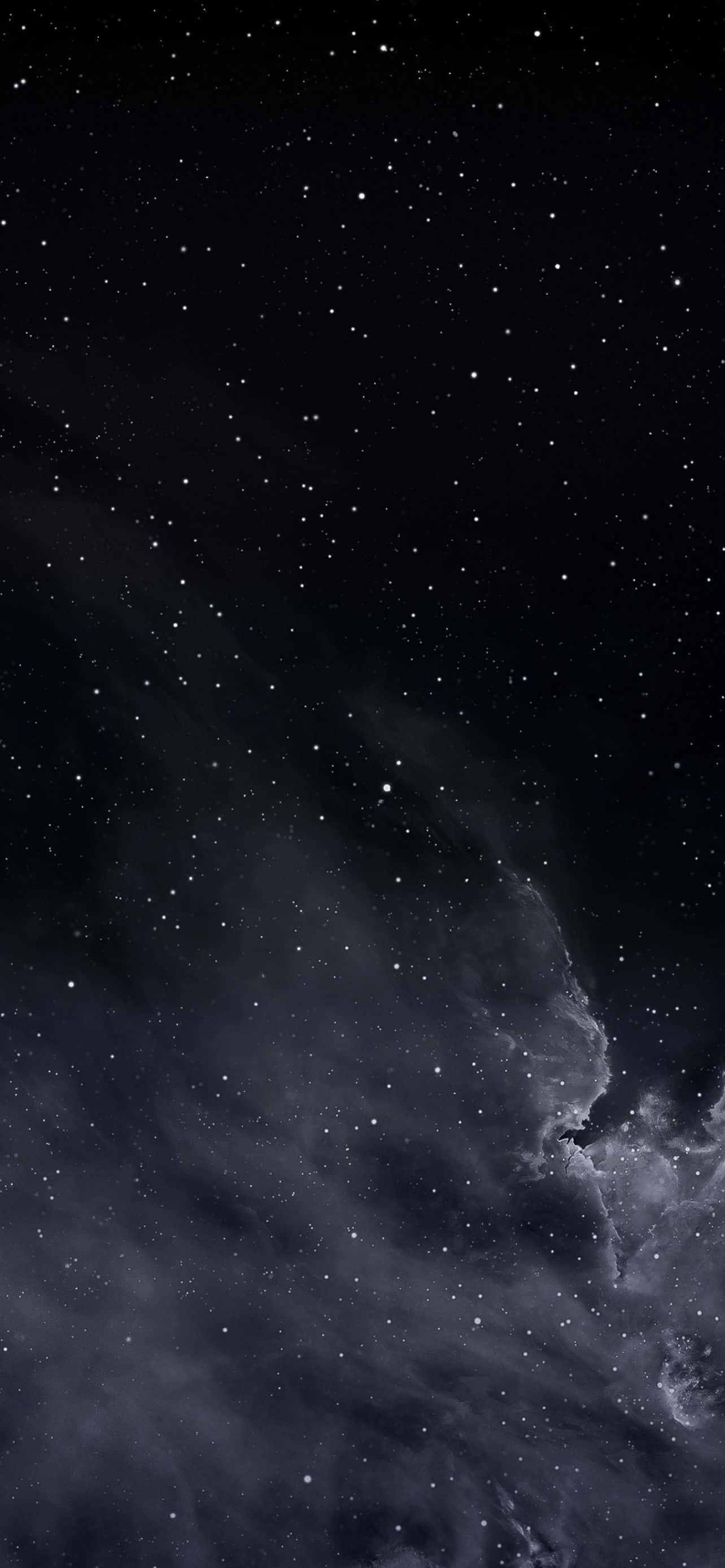 酷炫iPhone 桌布 壁紙 — 廣闊的宇宙場景，閃爍的星星散落在深邃的黑色太空，灰色和白色的漩渦星雲。