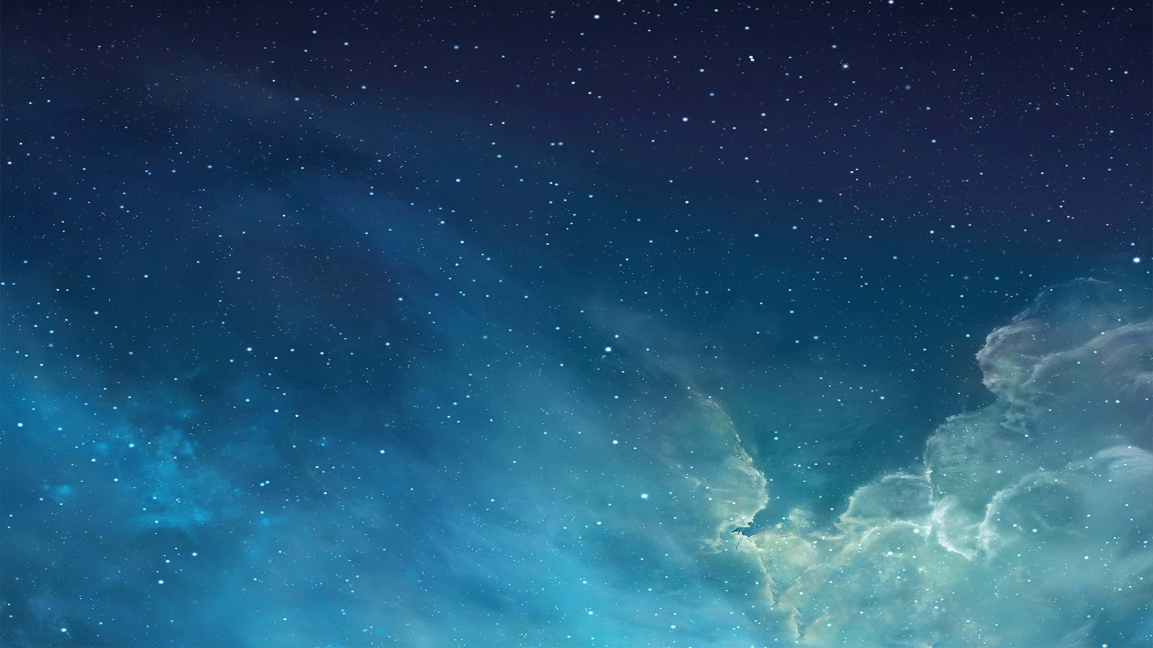 桌布 壁紙 — 廣闊的宇宙天空，充滿了閃爍的星星和發光的星雲，呈現深藍色和藍綠色調。