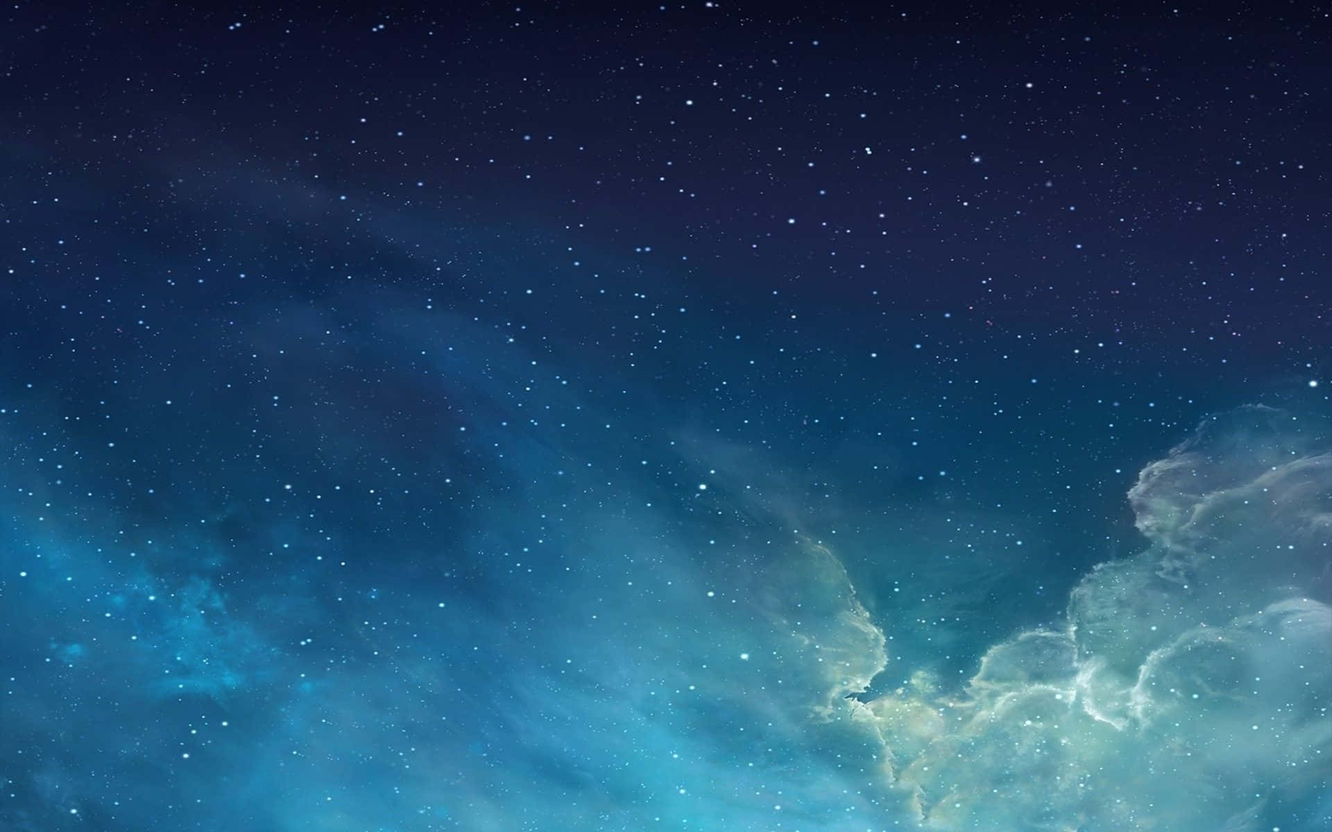 Mac 桌布 壁紙 — 廣闊的宇宙天空，充滿了閃爍的星星和發光的藍色星雲，在深空中飄蕩。