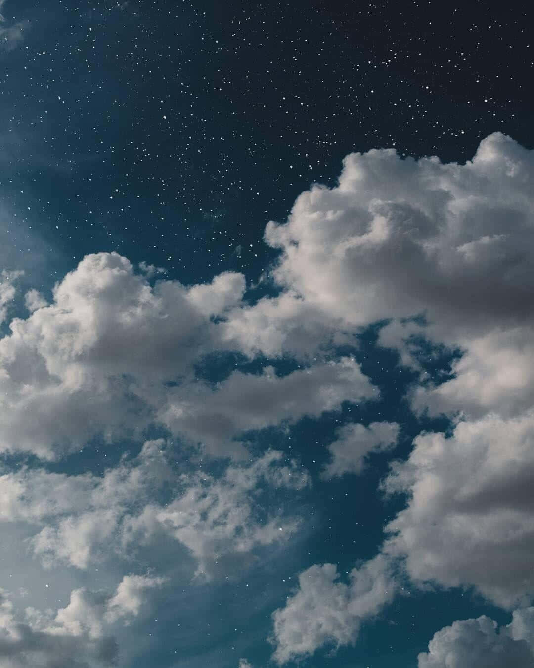 Blue And Gray 桌布 壁紙 — 廣闊的星空夜空，大量白雲在深靛藍色的天空中飄移。