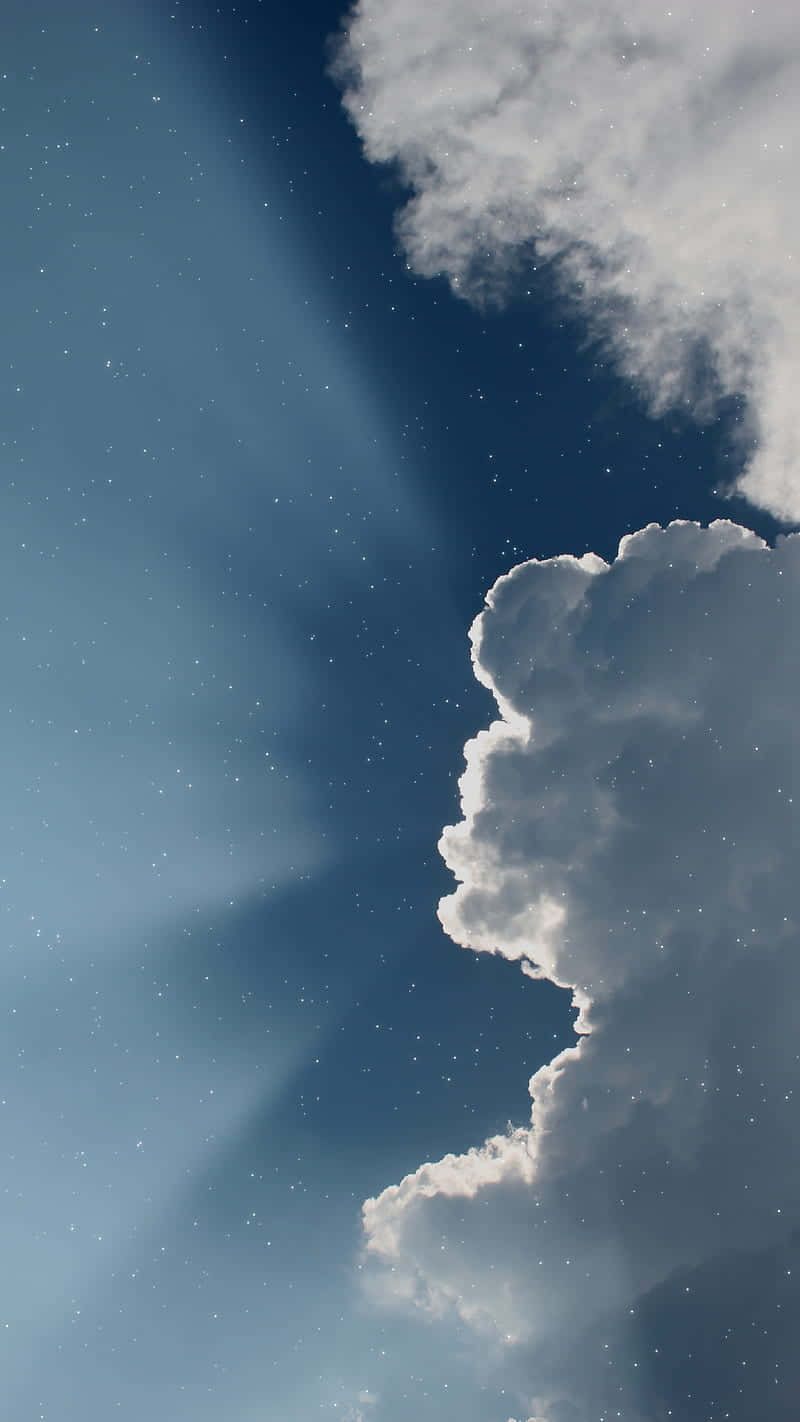 藍色美學 桌布 壁紙 — 廣闊的星空夜空，帶有戲劇性的雲層和穿透而過的燦爛月光光束。