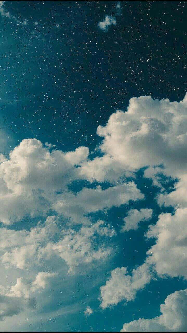 雲朵 桌布 壁紙 — 廣闊的星空夜空，蓬鬆的白雲飄過深藍綠色的天空。