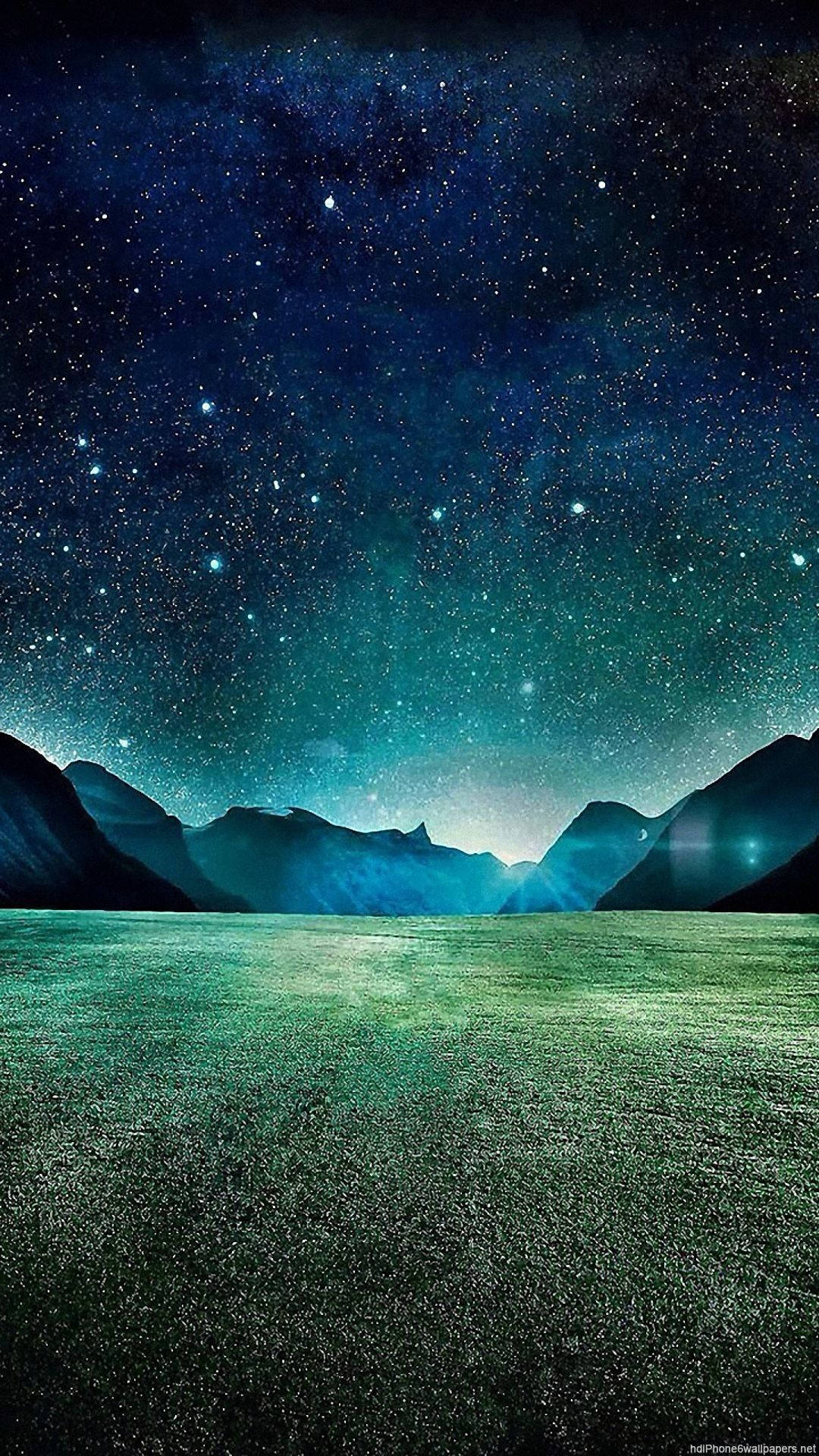 夜空 桌布 壁紙 — 廣闊的星空夜空在寧靜的綠色田野上空閃耀，遠方有暗黑的山脈。