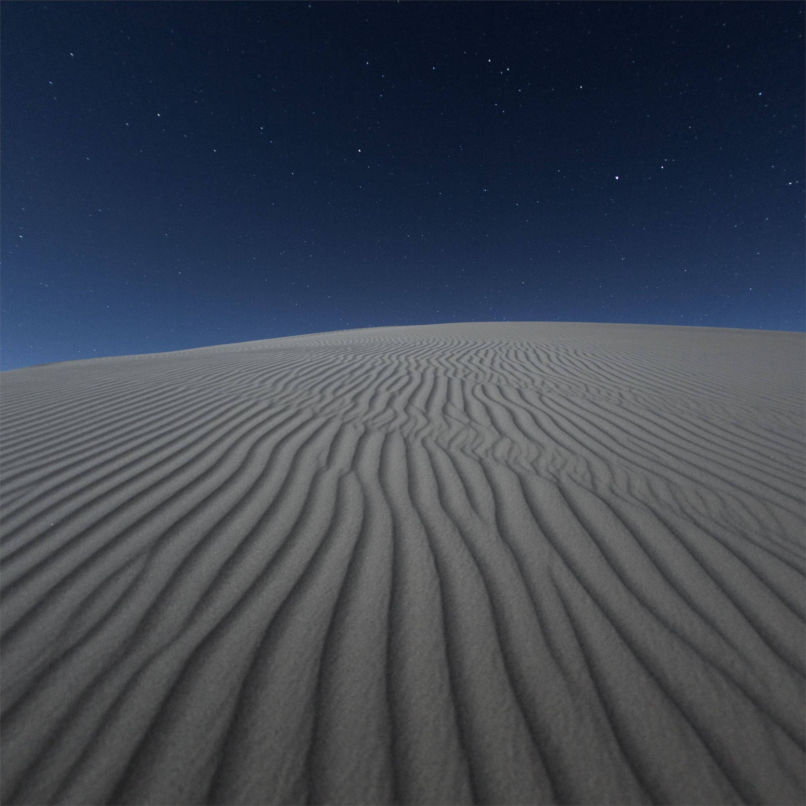 Desert 桌布 壁紙 — 廣闊的沙漠沙丘，在繁星點點的夜空下，波紋狀的沙灘延伸至地平線。
