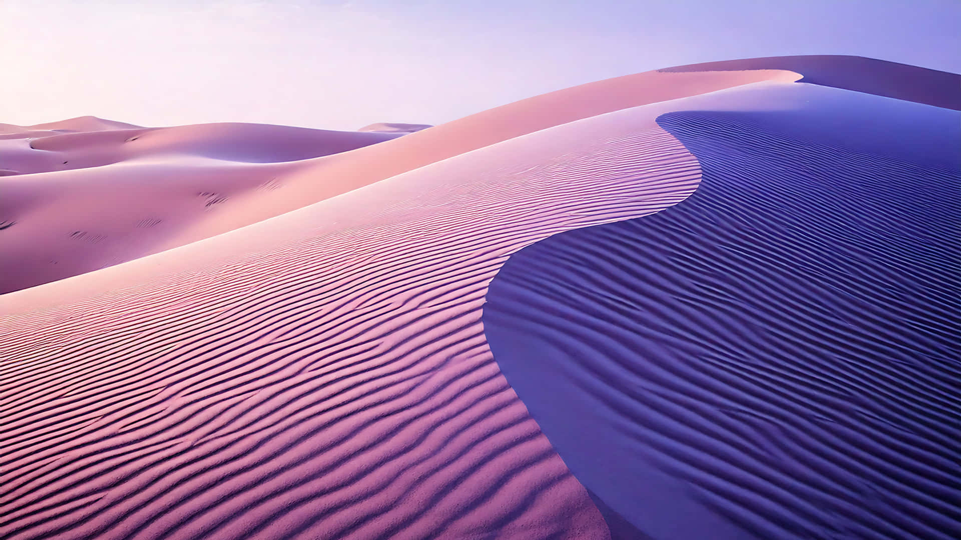 Purple Desert 壁紙 — 廣闊的沙漠沙丘在暮色天空下呈現柔和的粉紅色和紫色色調，波紋起伏。