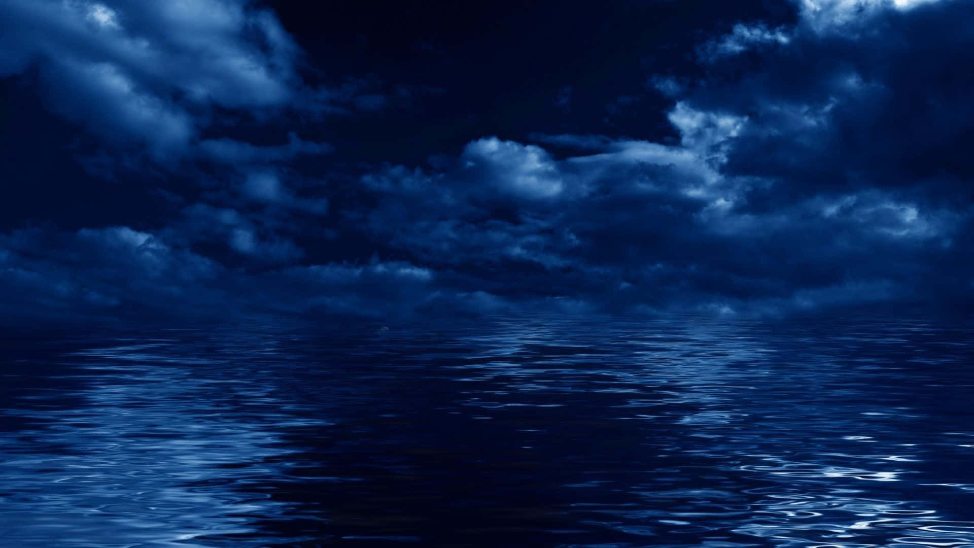 Dark Ocean 桌布 壁紙 — 廣闊的深藍色海洋映照著月光下充滿厚重雲層的暴風雨天空。