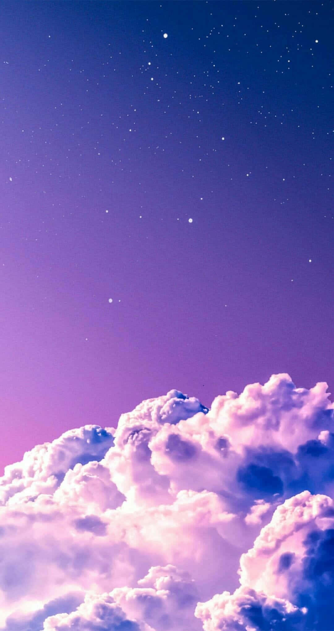 Lavender 桌布 壁紙 — 廣闊的紫色和藍色天空，佈滿星星，在粉紅色和薰衣草色調中閃爍的蓬鬆雲朵之上。