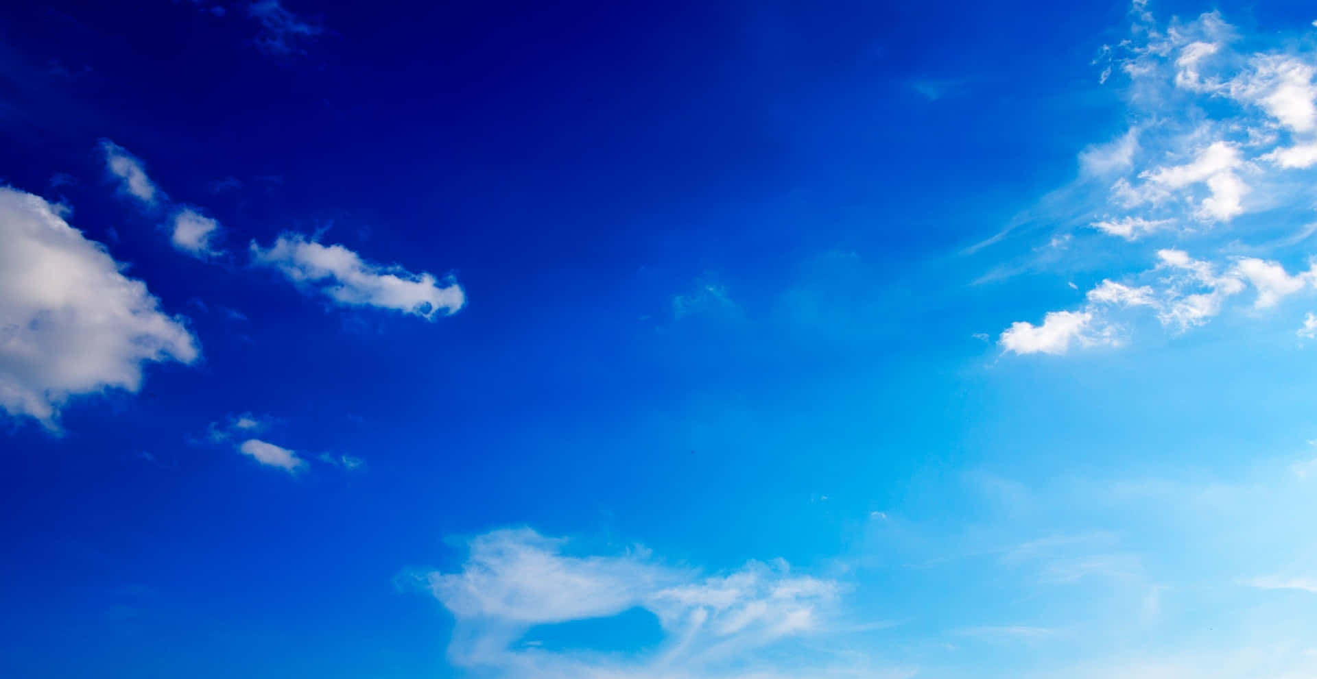 背景 桌布 壁紙 — 廣闊的蔚藍天空充滿了輕柔的白雲，在明亮的藍色空間中飄移。