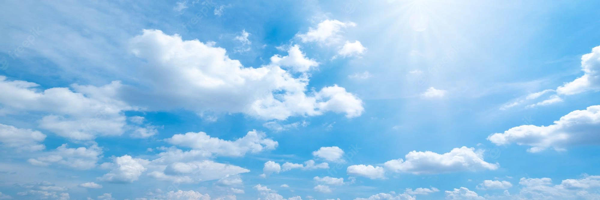 Clouds Aesthetics 桌布 壁紙 — 廣闊的藍天，充滿蓬鬆的白雲和穿透而過的燦爛陽光。
